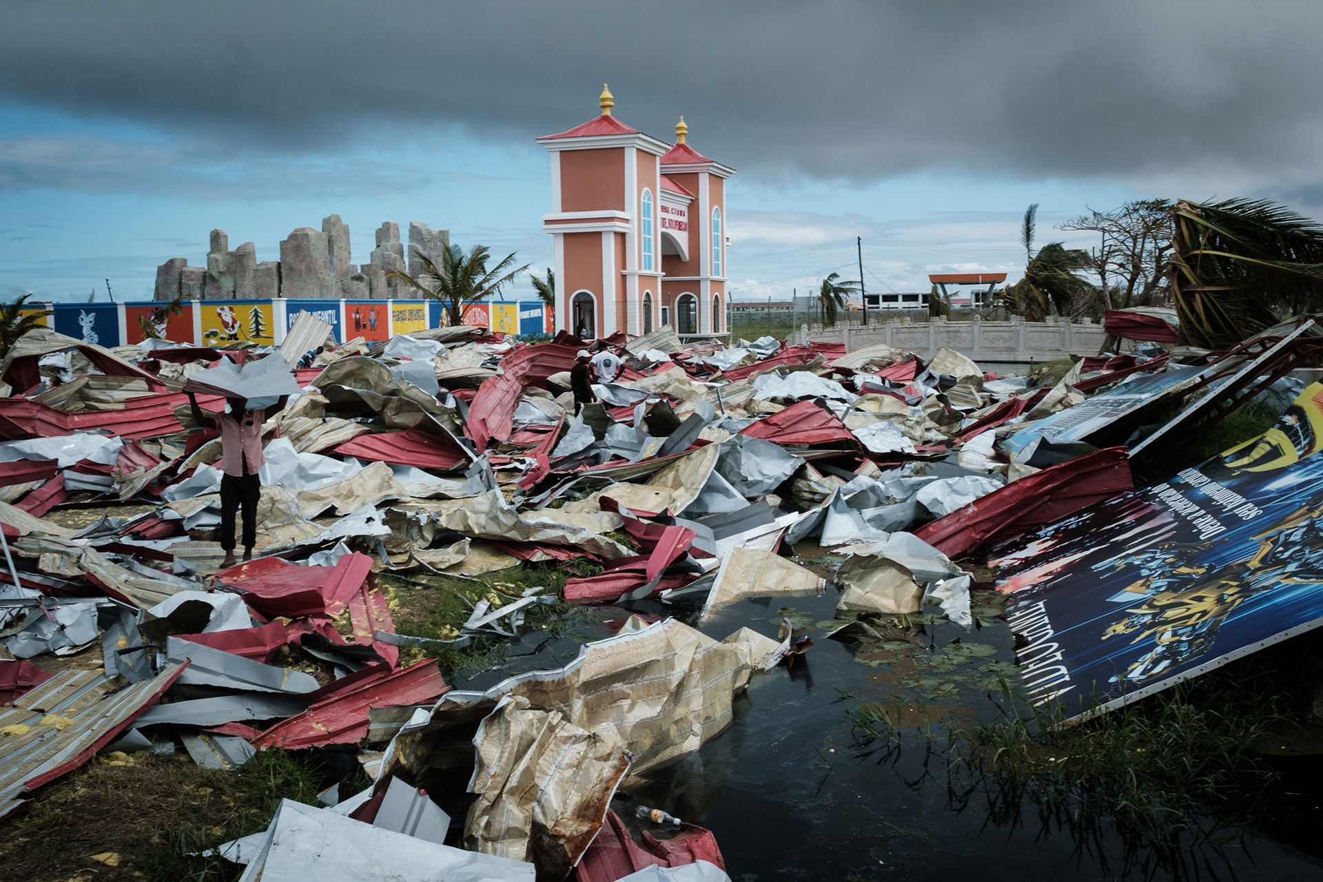Pobladores de Beira recolectan chapas de metal de un supermercado destruido por el ciclón, para reconstruir sus casas (Foto: Yasuyoshi CHIBA / AFP)