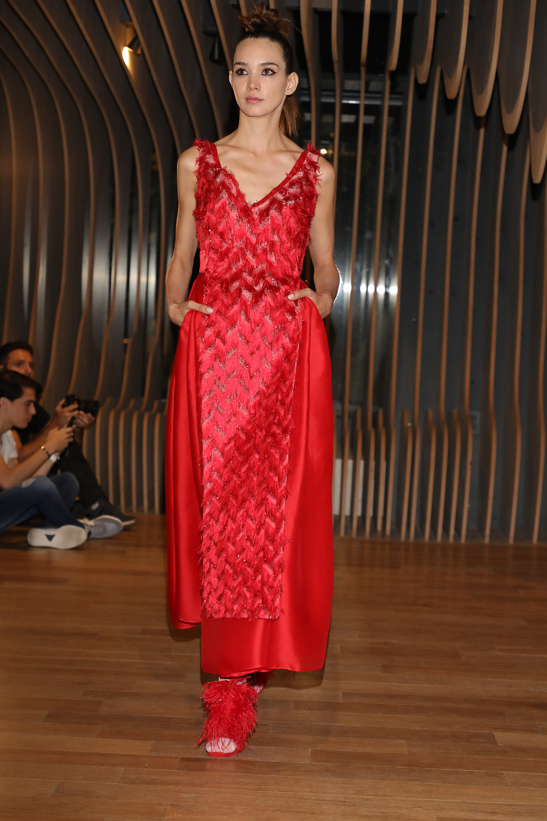 El color rojo es un clásico en las colecciones del modisto. Un comodín. Con bolsillos y al tobillo. Sin mangas y escote V. El detalle chic, el bordado de plumas