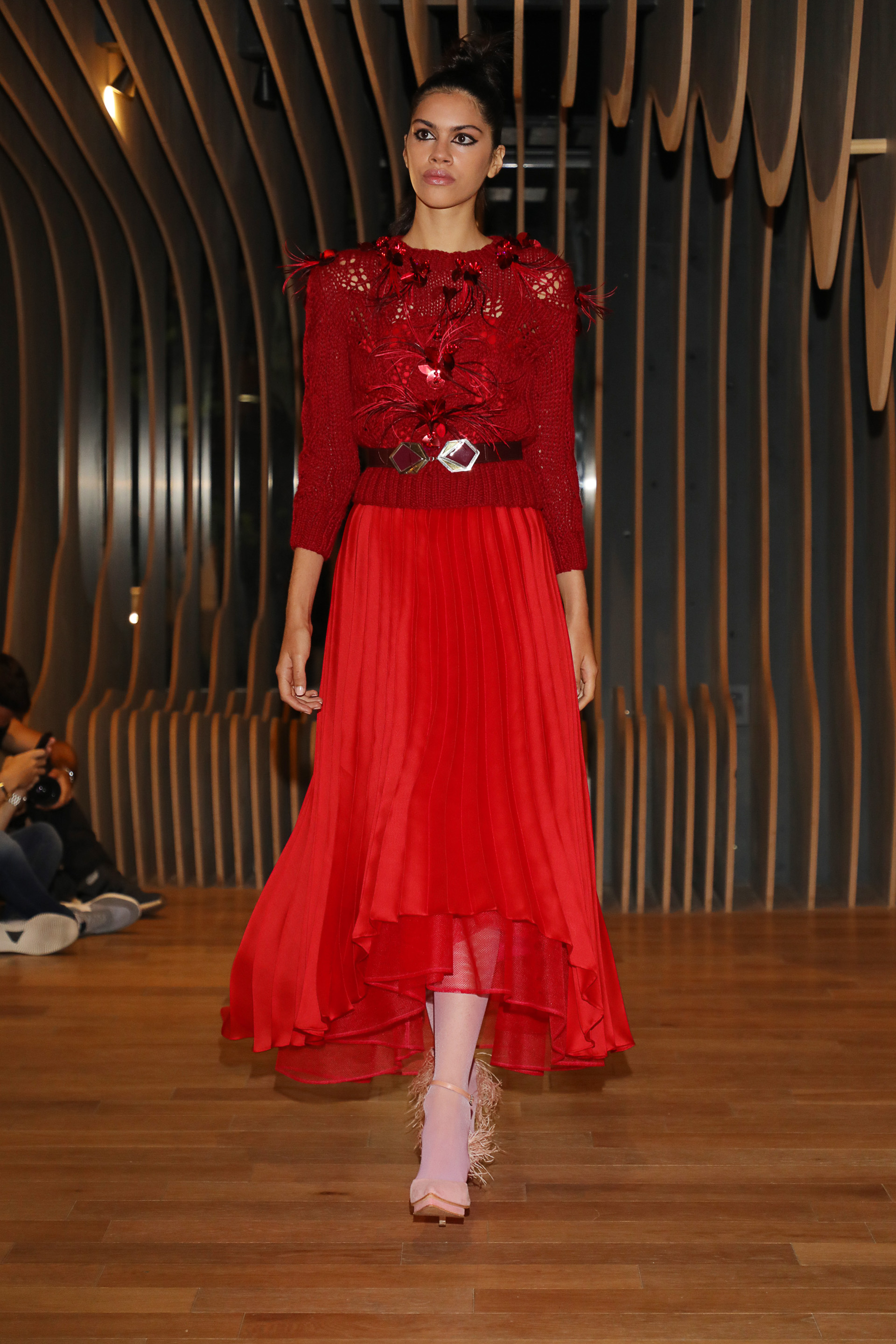 Plisado. Falda color rojo de la colección Oniria de gasa que completó el look de la blusa con detalles de flores y plumas