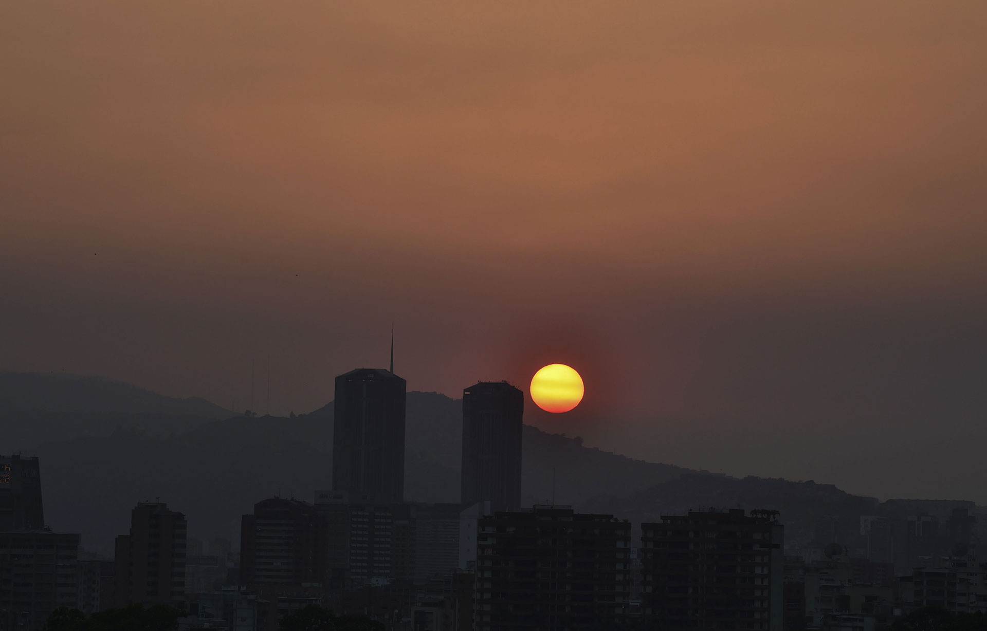 El sol se pone sobre una Caracas a oscuras durante el corte de luz que comenzó el 25 de marzo de 2019. (AFP)