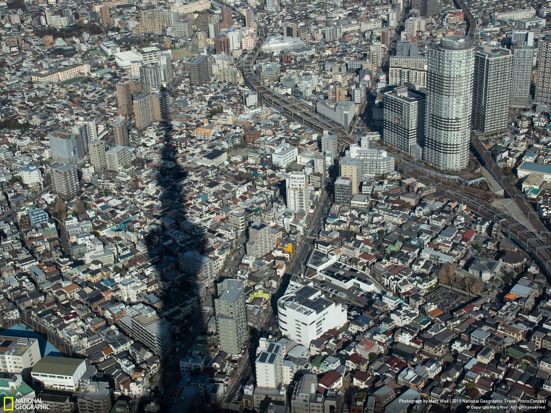 “Bajo el Skytree”, por Marc Woo: “Estaba en la terraza superior del Skytree alrededor del mediodía, cuando miré hacia afuera, noté que la sombra del Skytree y la calle se intersecaban como las manecillas de un reloj. También me sorprendió la cantidad de hogares que hay debajo del Skytree”. (“Under the Skytree / 2019 National Geographic Travel Photo Contest / Categoría: Ciudades / Ubicación: Sumidacho, Tokio, Japón)