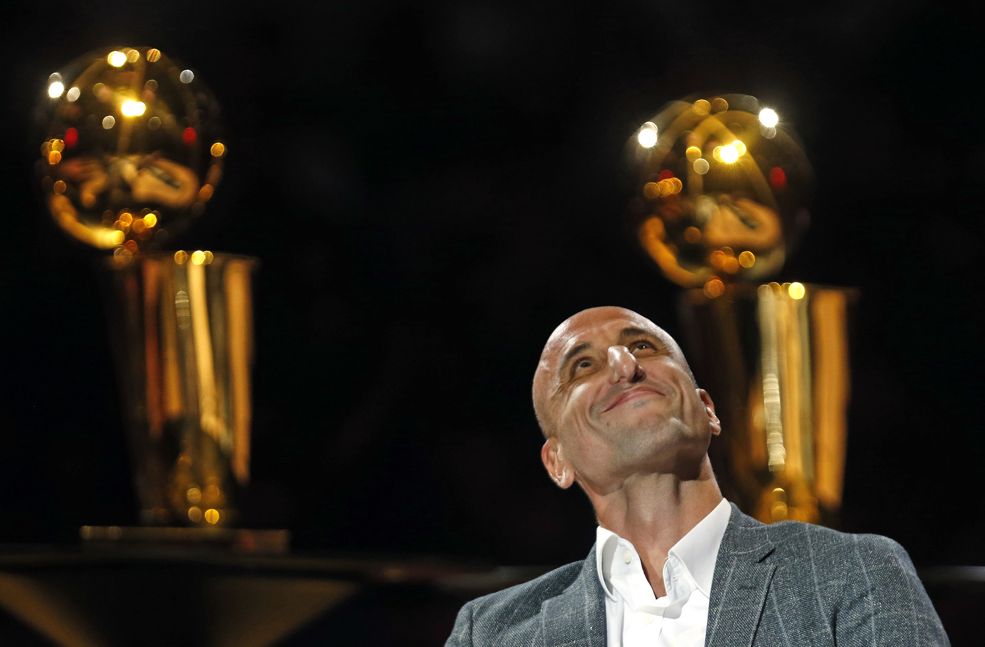 Manu Ginóbili ve una película sobre su carrera en el día en el que se decidió el retiro de su número. En el fondo, dos de los cuatro trofeos de campeonato que ganó con los San Antonio Spurs en AT&T Center