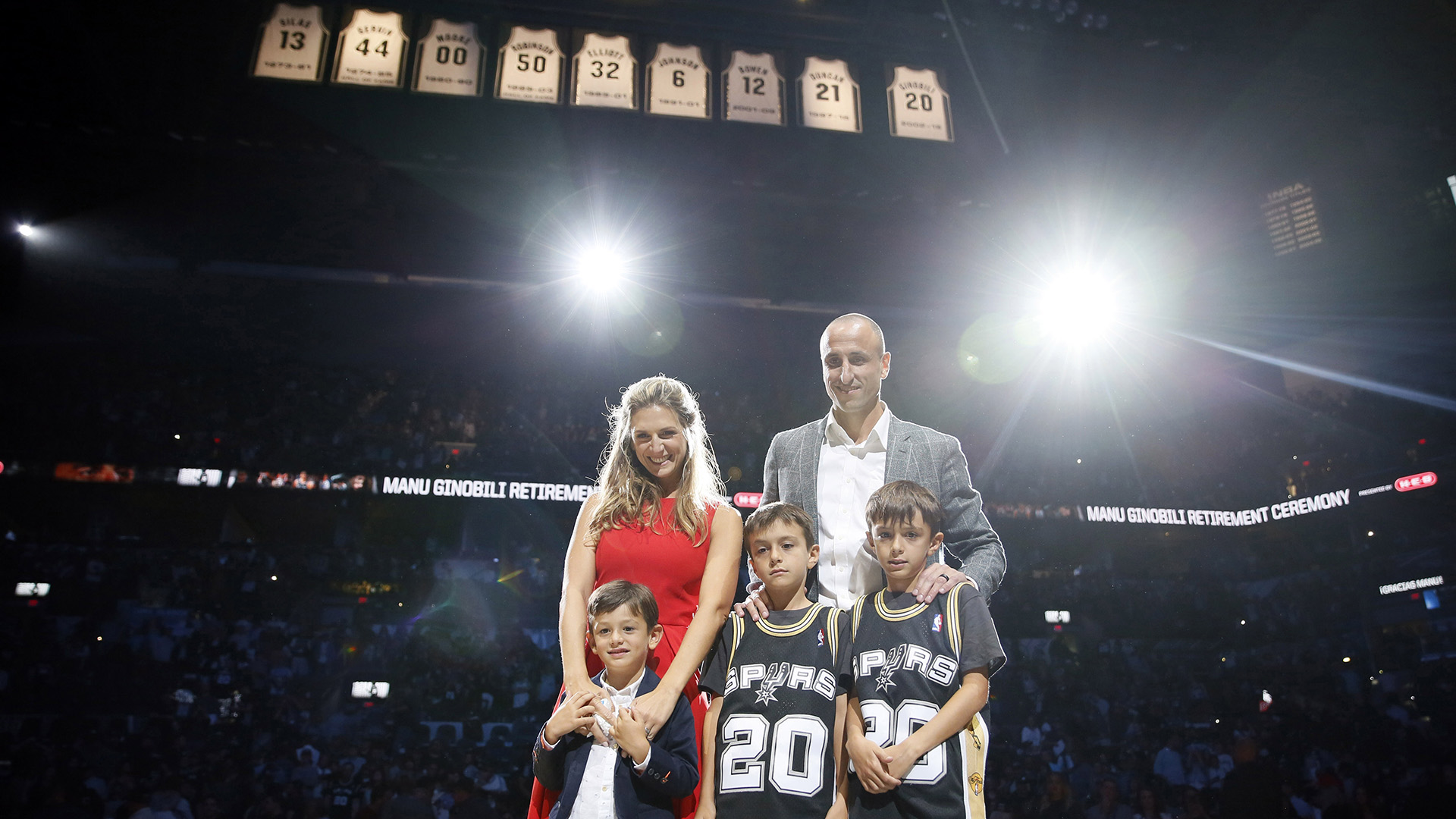 El ex jugador de los San Antonio Spurs, Manu Ginóbili, posa para una foto con su familia después de su ceremonia de retiro en el AT&T Center tras un partido entre los Cleveland Cavaliers y los San Antonio Spurs