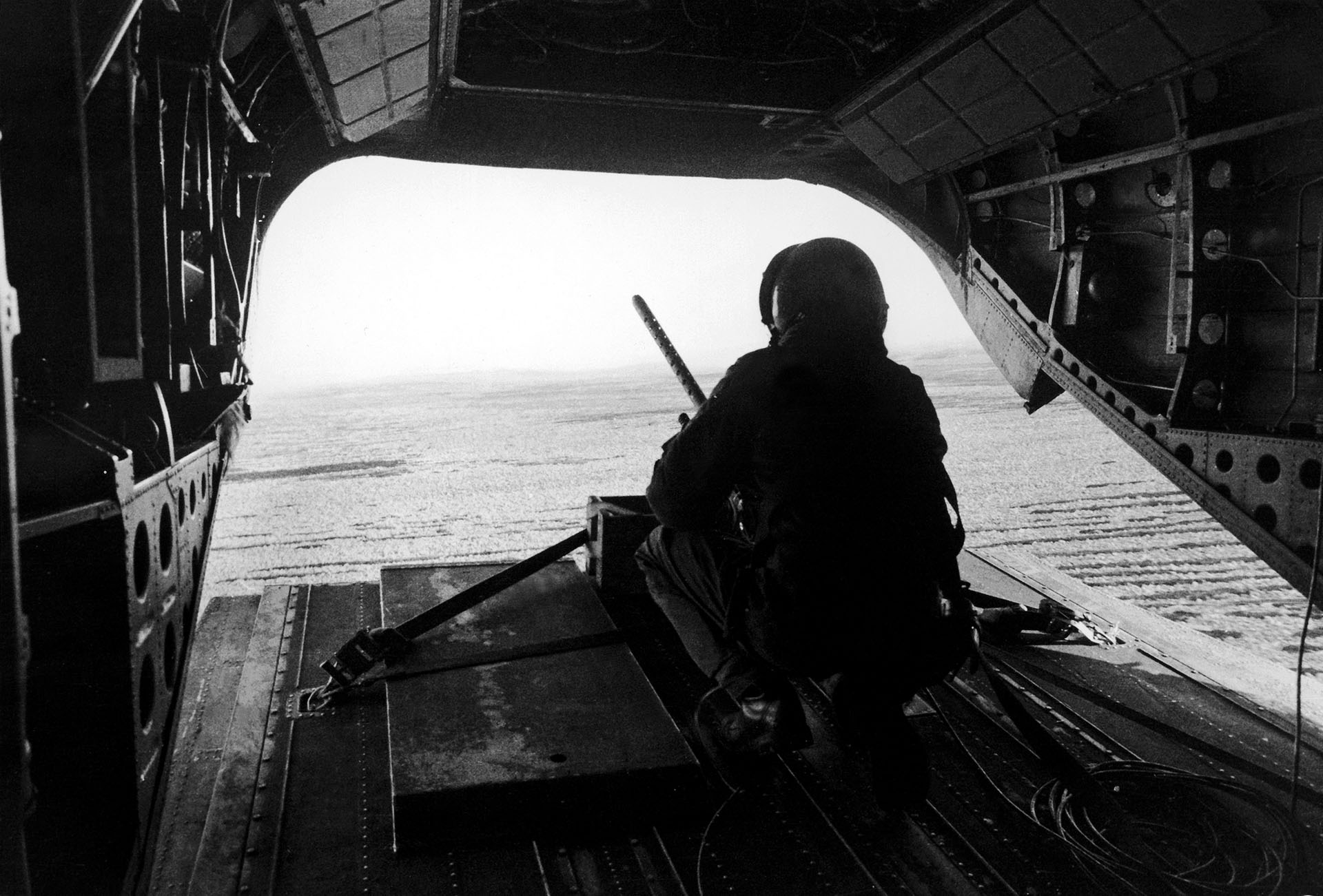 Desde la parte trasera de un helicóptero Chinook, vigila las posiciones argentinas durante un vuelo entre el estrecho San Carlos y Pradera del Ganso. El arma permanece fija en sus anclajes (Foto: Eduardo Farré).