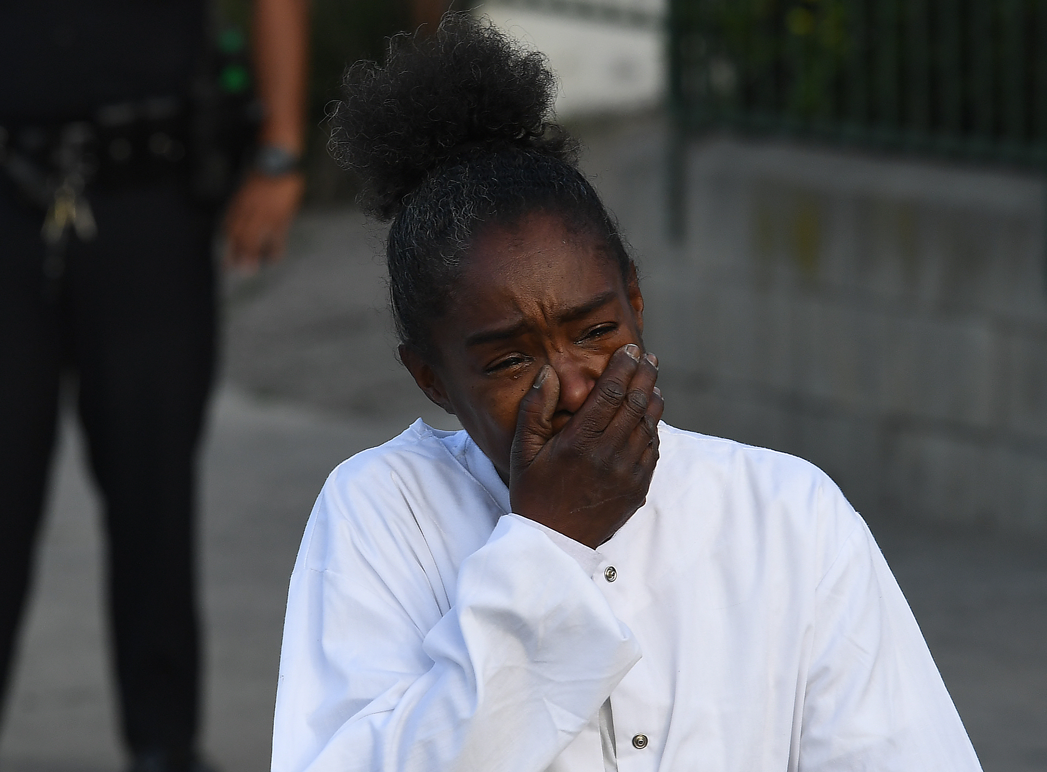 Una mujer llora frente a la tienda de Hussle (Mark RALSTON / AFP)