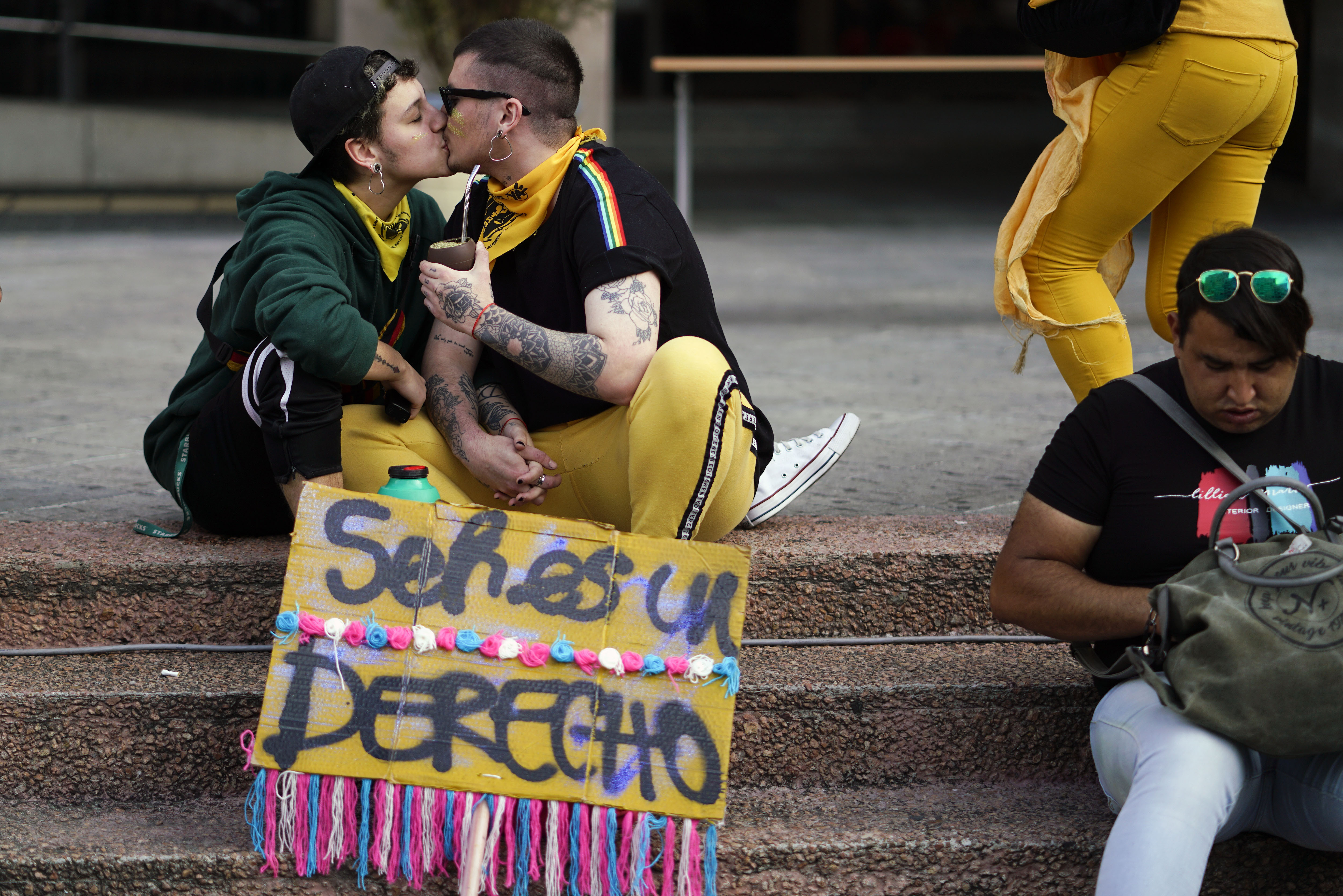 Una pareja se besa en la marcha. (AP Photo/Matilde Campodonico)