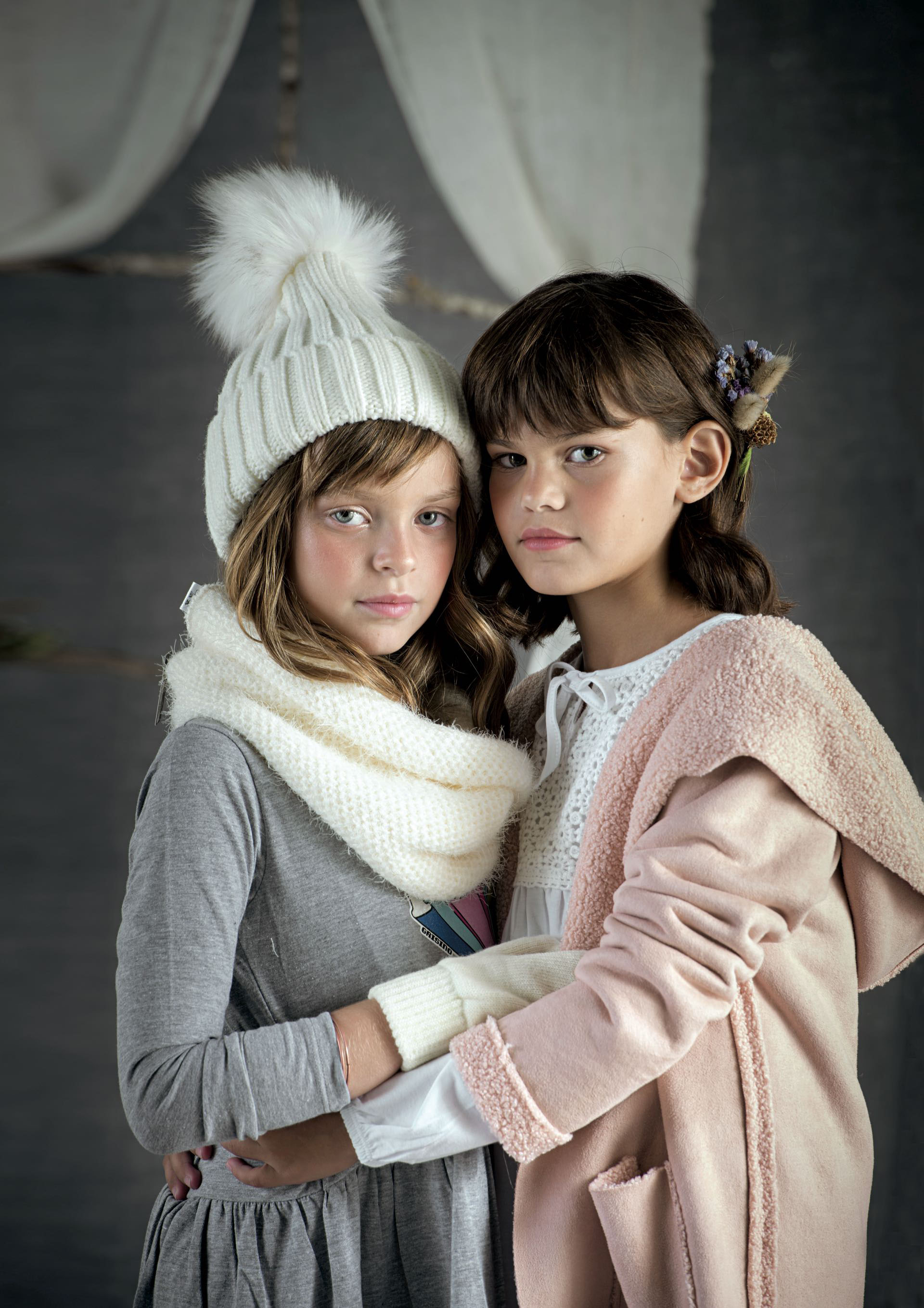 Oli: Vestido de algodón (Grisino), cuello de lana y gorro con pompón (Todo moda). Nina: tapado gamuzado ( Stai Zitta) y remera con pechera de broderie(Mimo & Co).