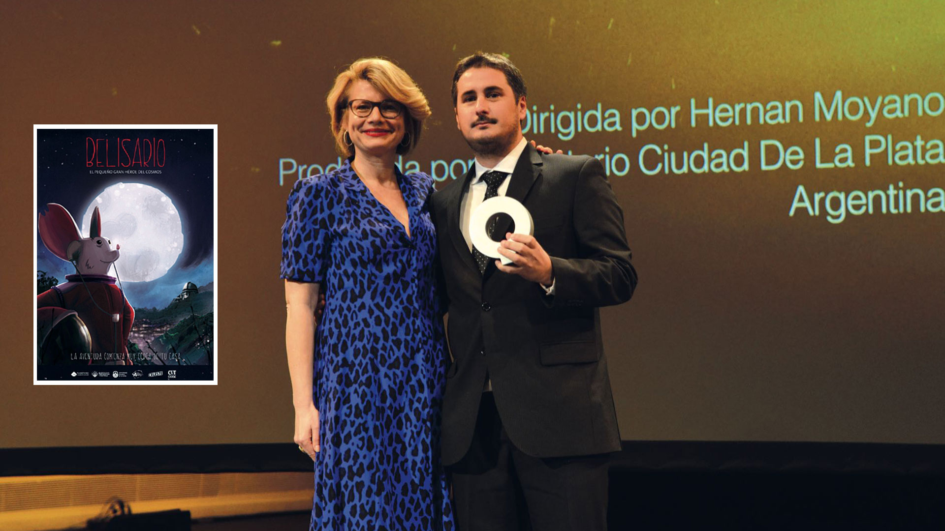 Hernán Moyano recibe el premio en las españolas Islas Canarias. Al lado, el afiche de Belisario, el pequeño gran héroe del cosmos: un ratón que se convirtió en león.