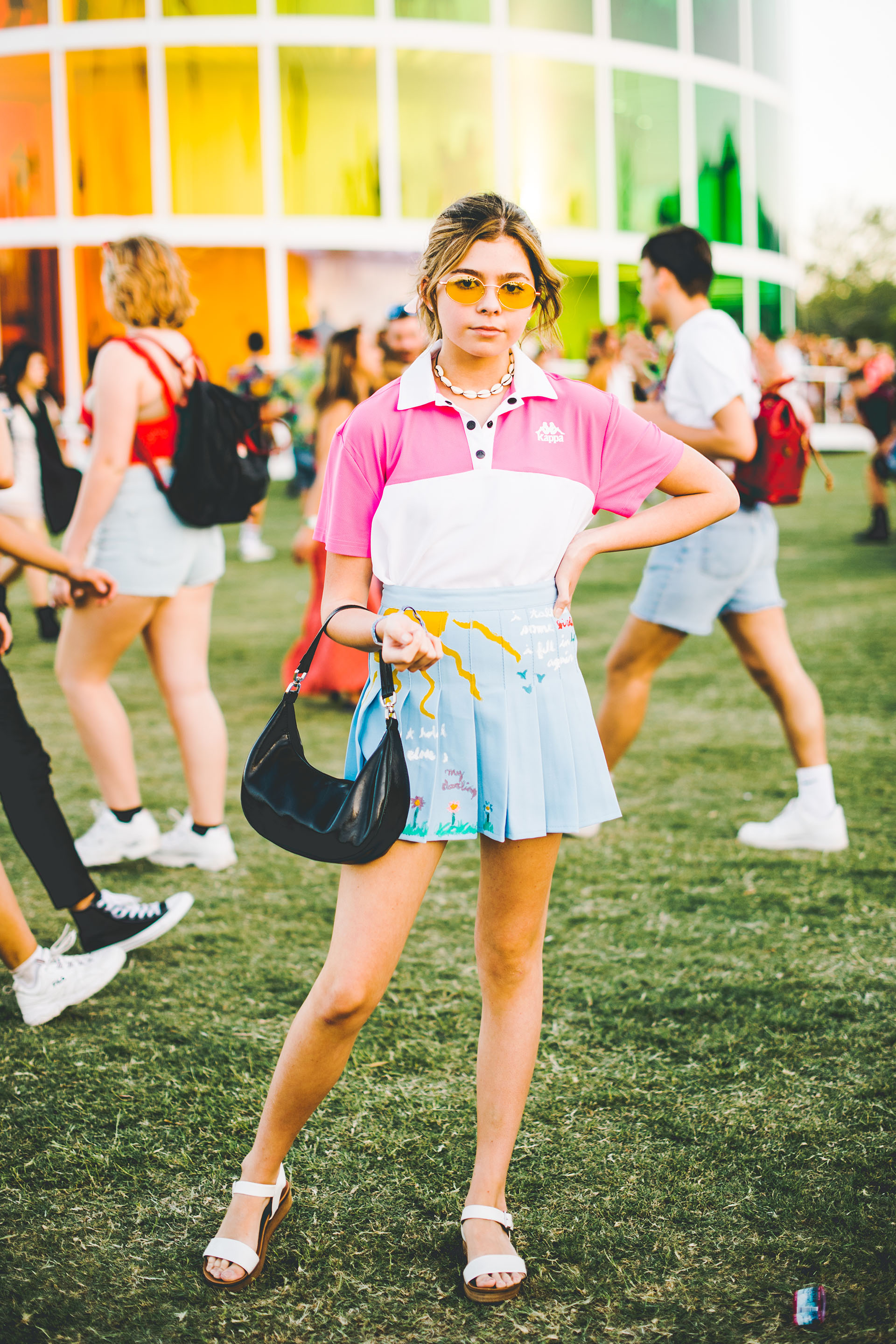 La falda con estamapa tableada, la remera estilo polo Kappa y cartera vintage con lentes de color amarillo. El toque fashionista está en su accesorio, el chocker de caracoles, última moda entre las adolescentes en los festivales