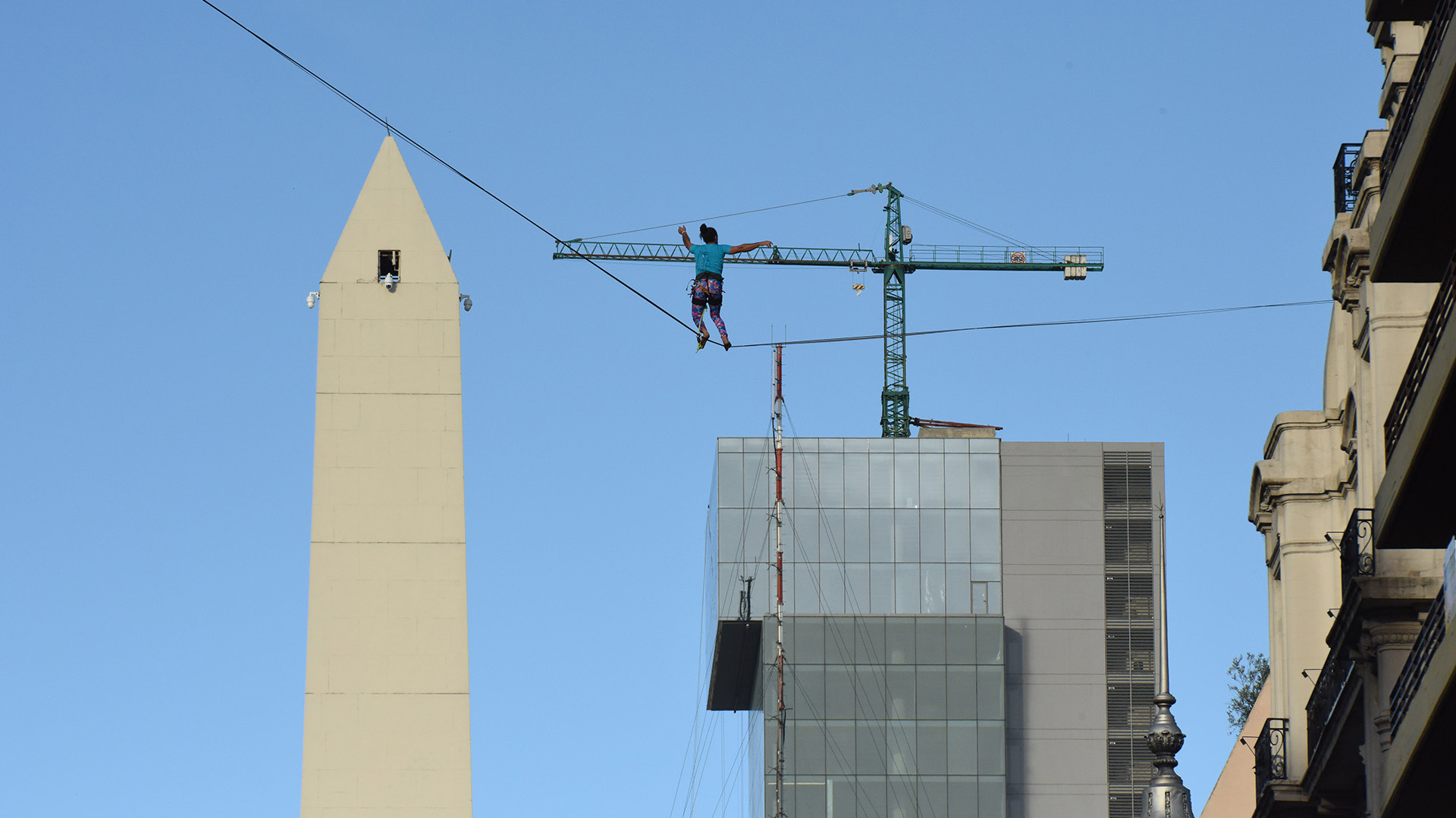 Una mujer haciendo equilibrio con el Obelisco de fondo