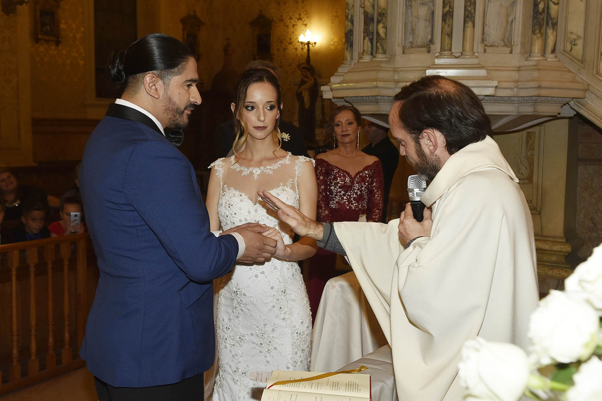 El cura bendiciendo los anillos de matrimonio de Ariel Puchetta y Camila Minoldo