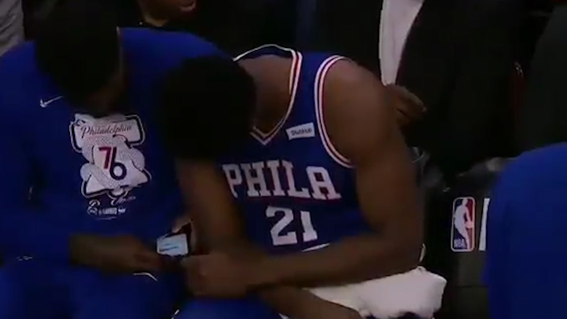 Amir Johnson y Joel Embiid viendo el celular