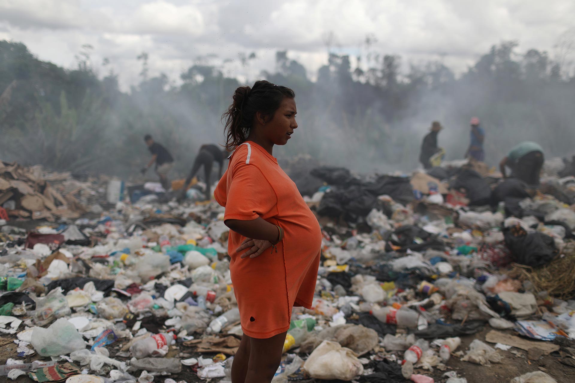 Una mujer embarazada de 8 meses también revuelve la basura (REUTERS/Pilar Olivares)