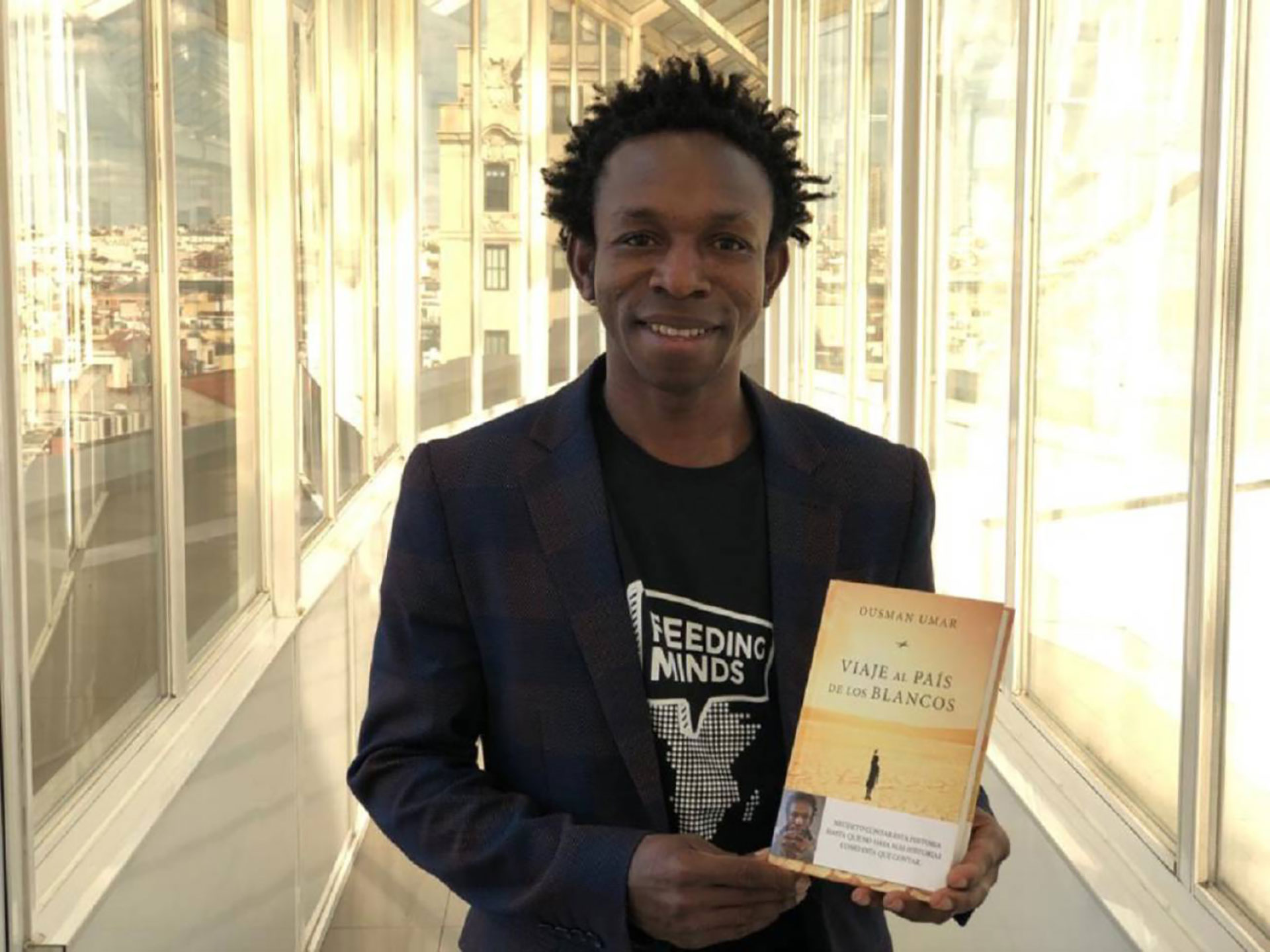 Ousman Umar muestra orgulloso su primer libro autobiográfico, “El país de los blancos”. (Foto: Cadena Ser)