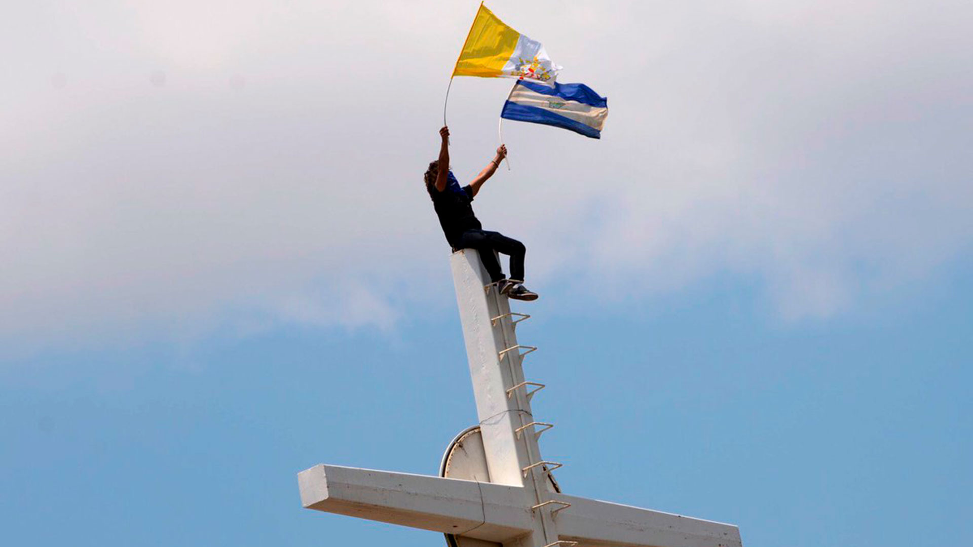 Un manifestante ondea las banderas de Nicaragua y el Vaticano