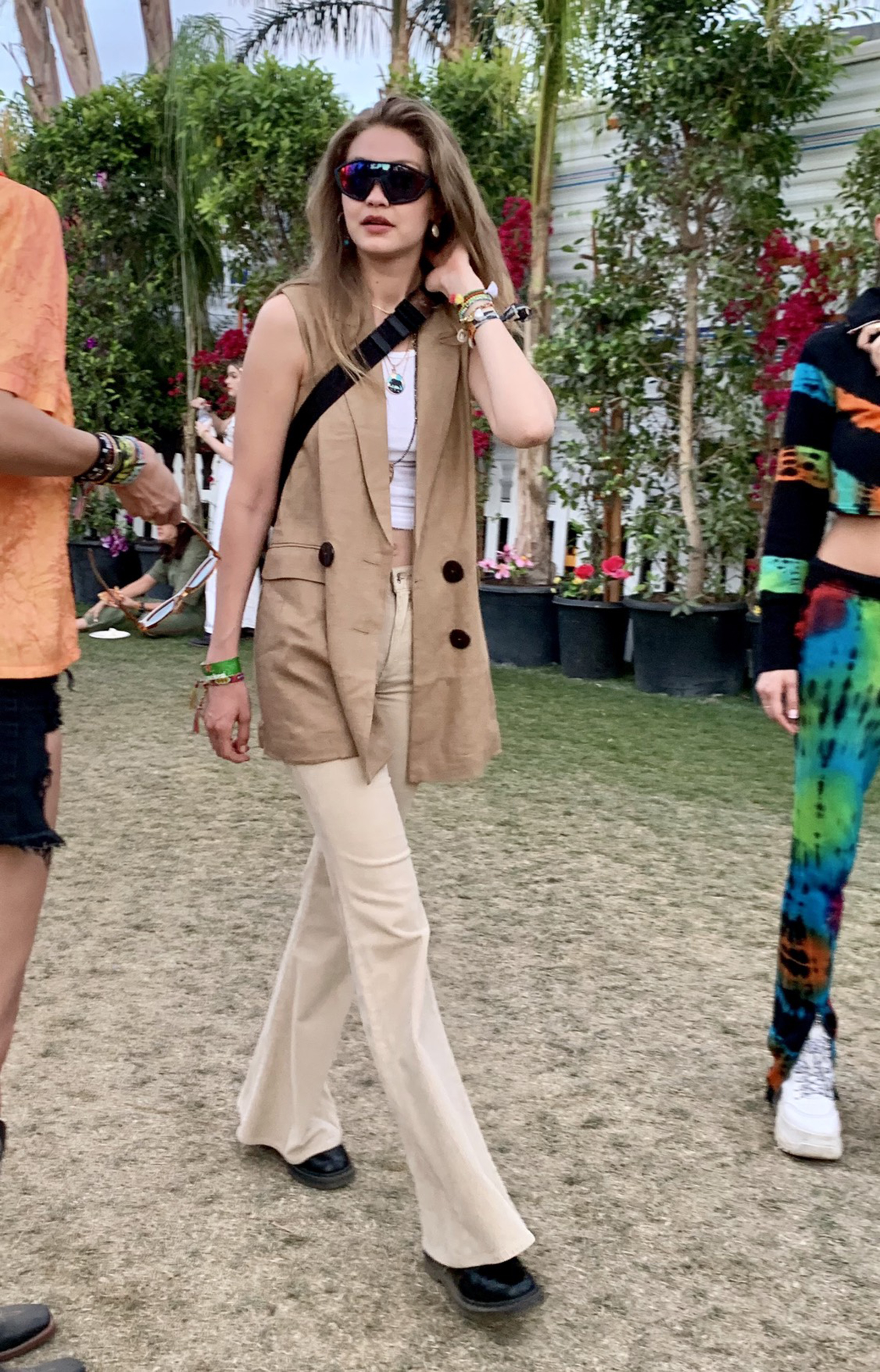Gigi Hadid no se quiso perder el festival más top de California y apostó a un look más safari. Un chaleco de gamuza con maxi botones en marrón, un top blanco y pantalones de gabardina. Completó su look con pulseras de hilo y anteojos XL tornasol espejados