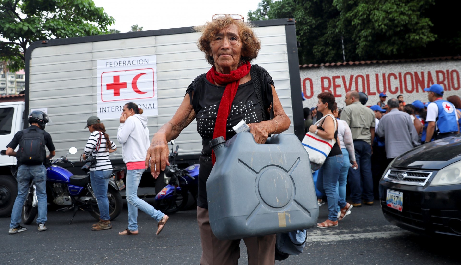 Una mujer carga un envase para agua repartido por la Cruz Roja (Reuters)
