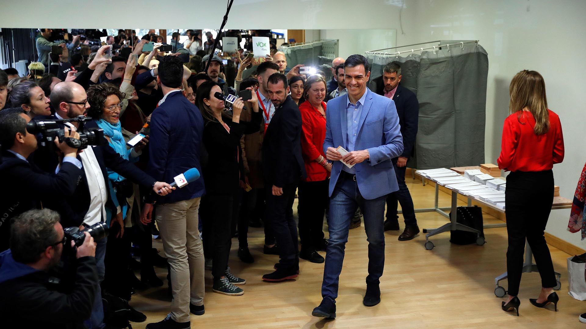 El presidente del gobierno Pedro Sánchez y su mujer Begoña Gómez se disponen a votar en un colegio de la localidad madrileña de Pozuelo de Alarcón bajo la atenta mirada de la prensa. (Foto: EFE/Emilio Naranjo)