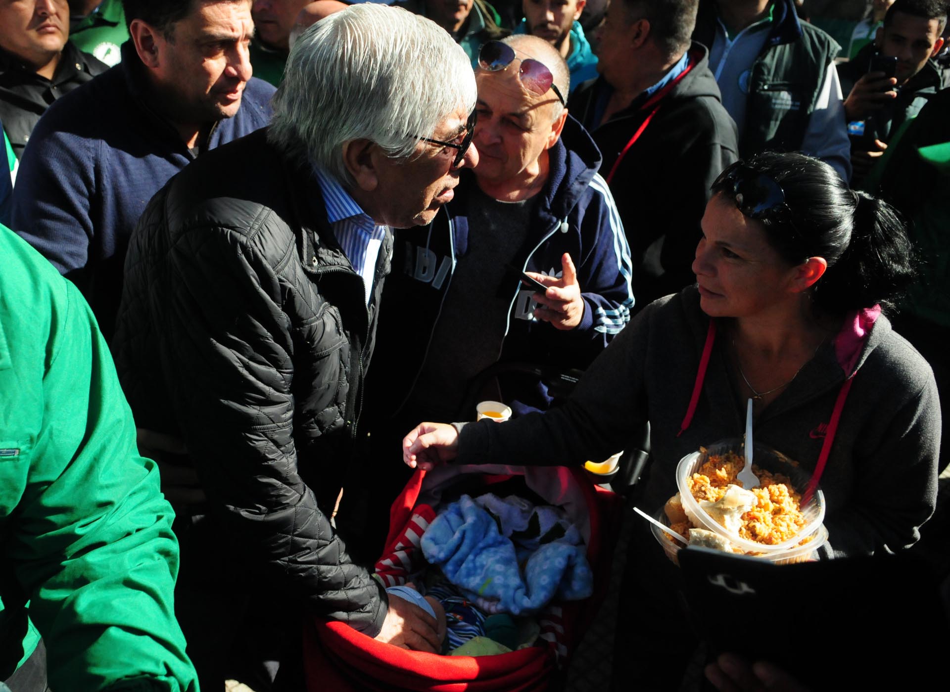 Hugo Moyano junto a una integrante de una agrupación social que se acercó a buscar su plato de comida