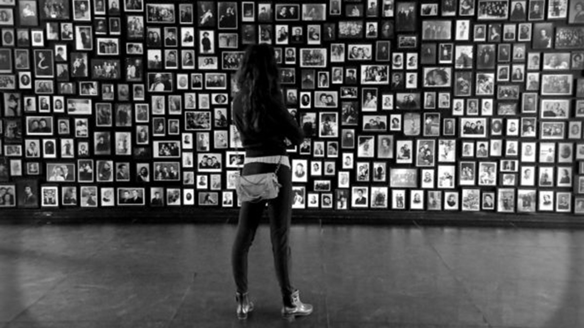 Una mujer observa fotografías de víctimas del Holocausto en un museo