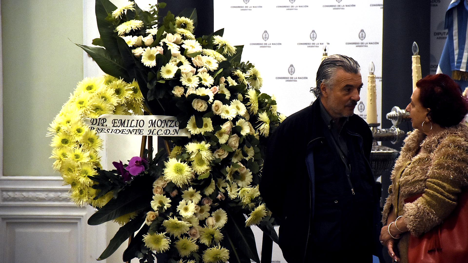 El médico sanitarista Juan Carlos Biani (Frente de Técnicos y Profesionales peronistas). A la izquierda, la corona enviada por Emilio Monzó, presidente de la Cámara de Diputados de la Nación