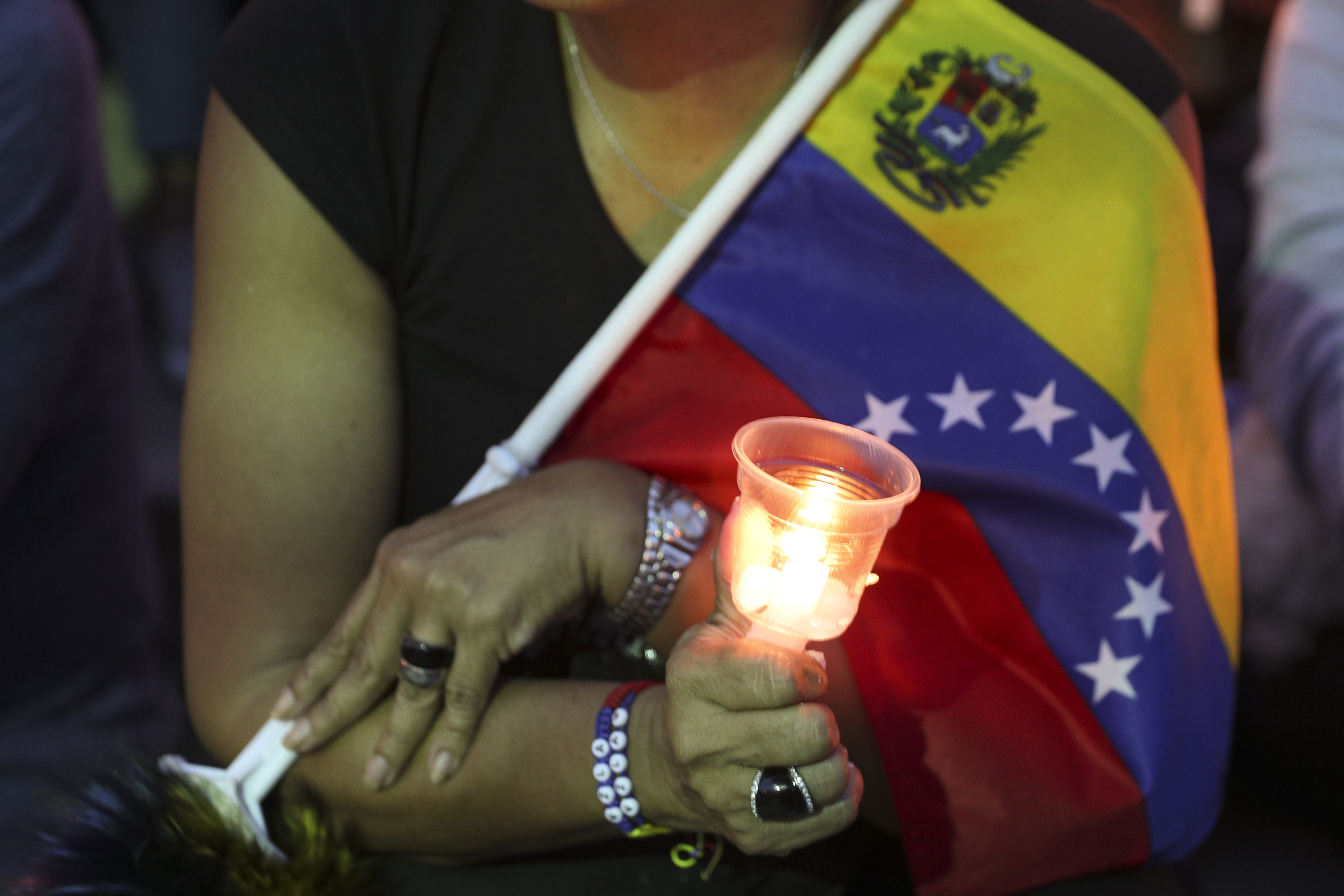 Una opositora al gobierno del presidente Nicolás Maduro sostiene una vela durante una vigilia para aquellos que fallecieron en enfrentamientos la semana pasada en Caracas, Venezuela, el domingo 5 de mayo de 2019. (AP Foto/Martin Mejia)