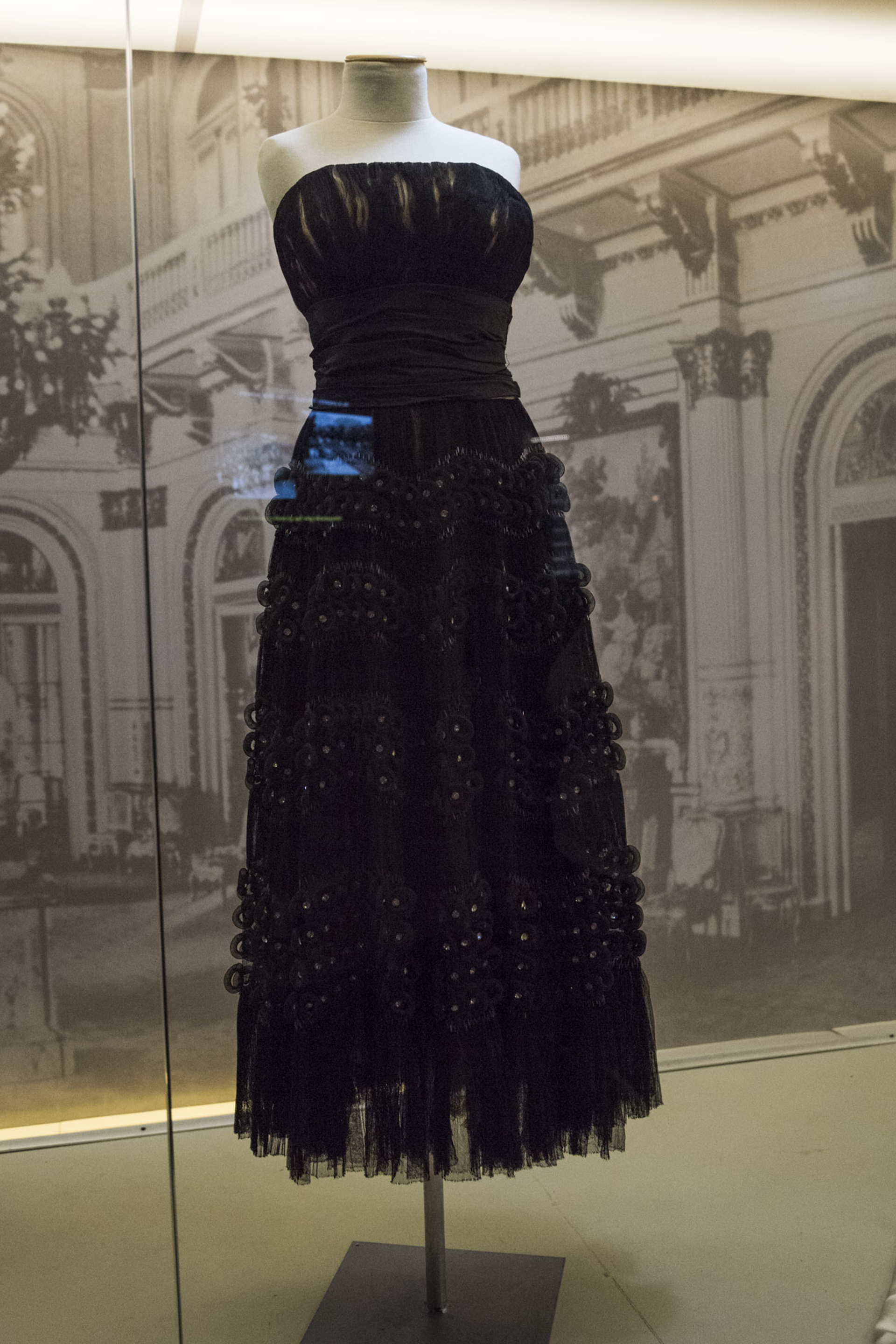 Vestido strapless realizado en tul, falda fruncida con detalles de canutillos, apliques en villoné y strass de Genevieve Loussette
