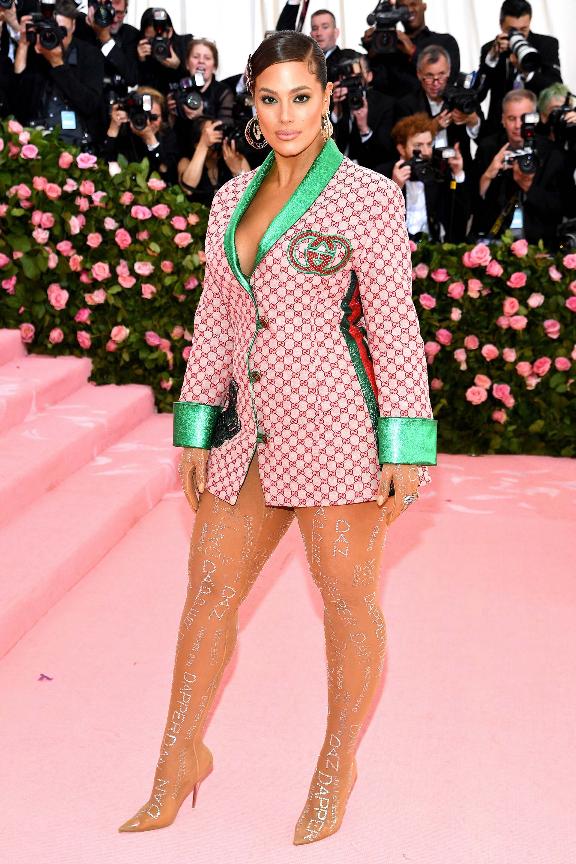 En medias con apliques y solo una chaqueta Gucci, la modelo Ashley Graham optó por un look atrevido que acompañó con una trenza larga, hebillas y aros
