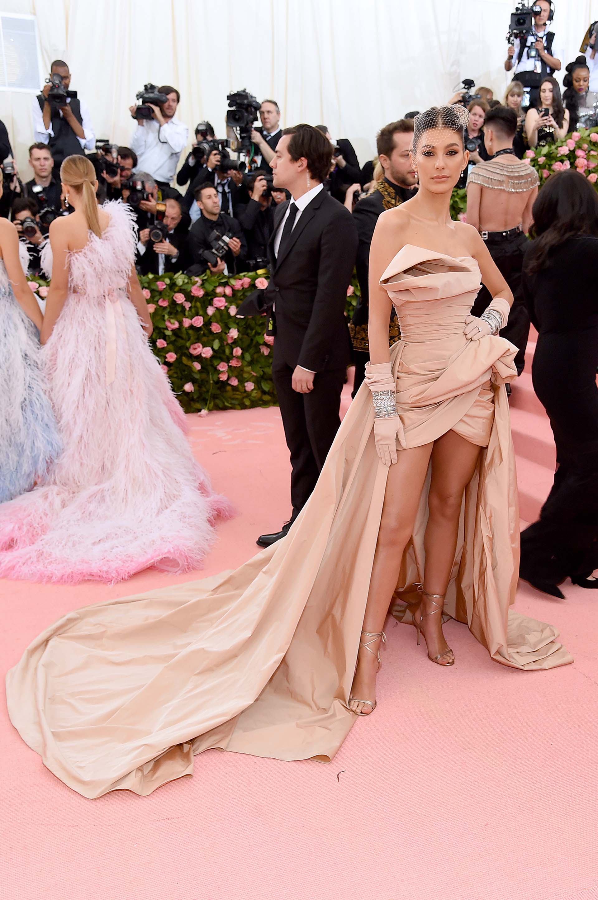 La argentina Camila Morrone lució un vestido color nude con guantes y sandalias a tono, y un velo de red