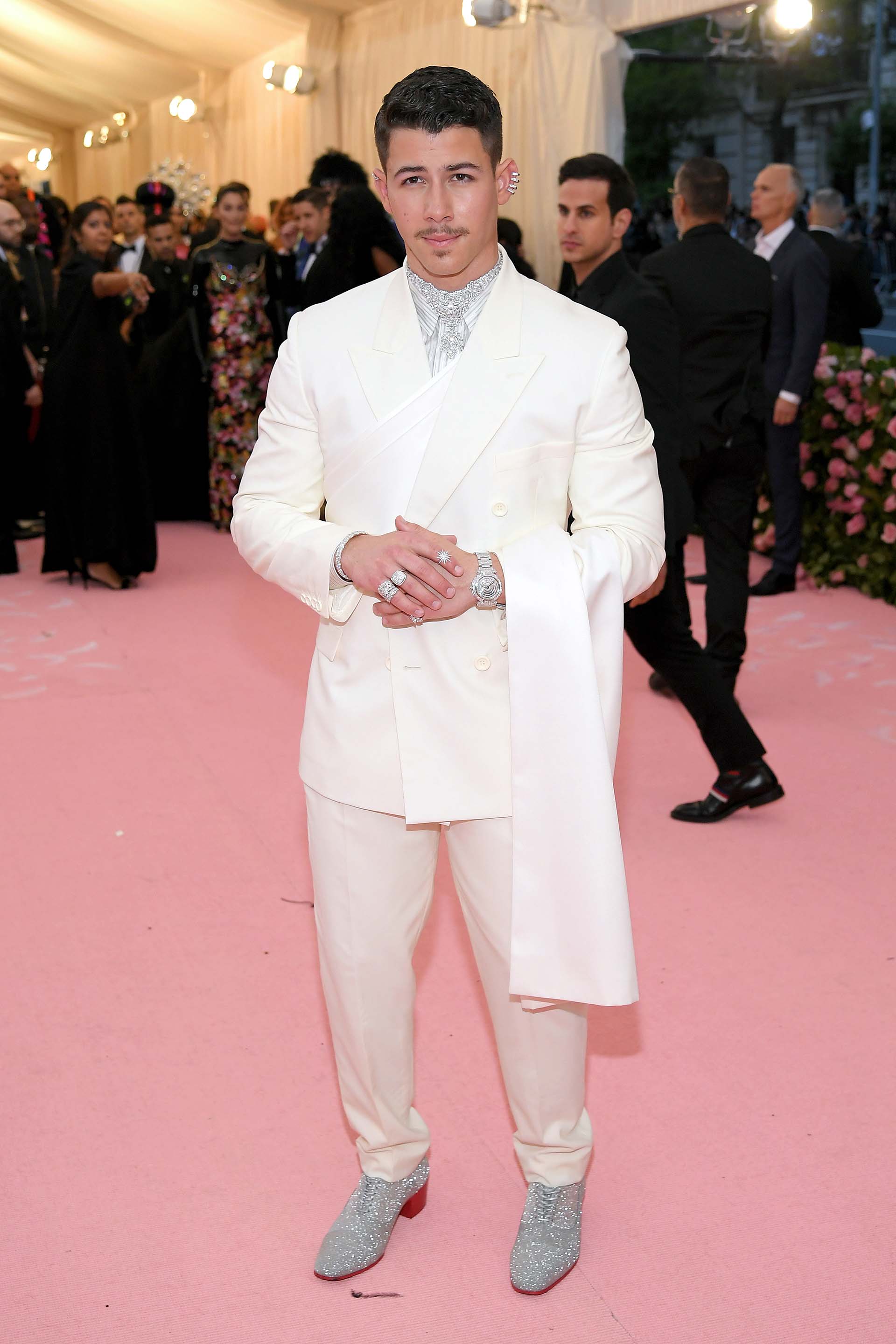 Nick Jonas, también con un look de Dior, apostó a los brillos, a las jojas y al maquillaje para darle un tono camp a su traje blanco