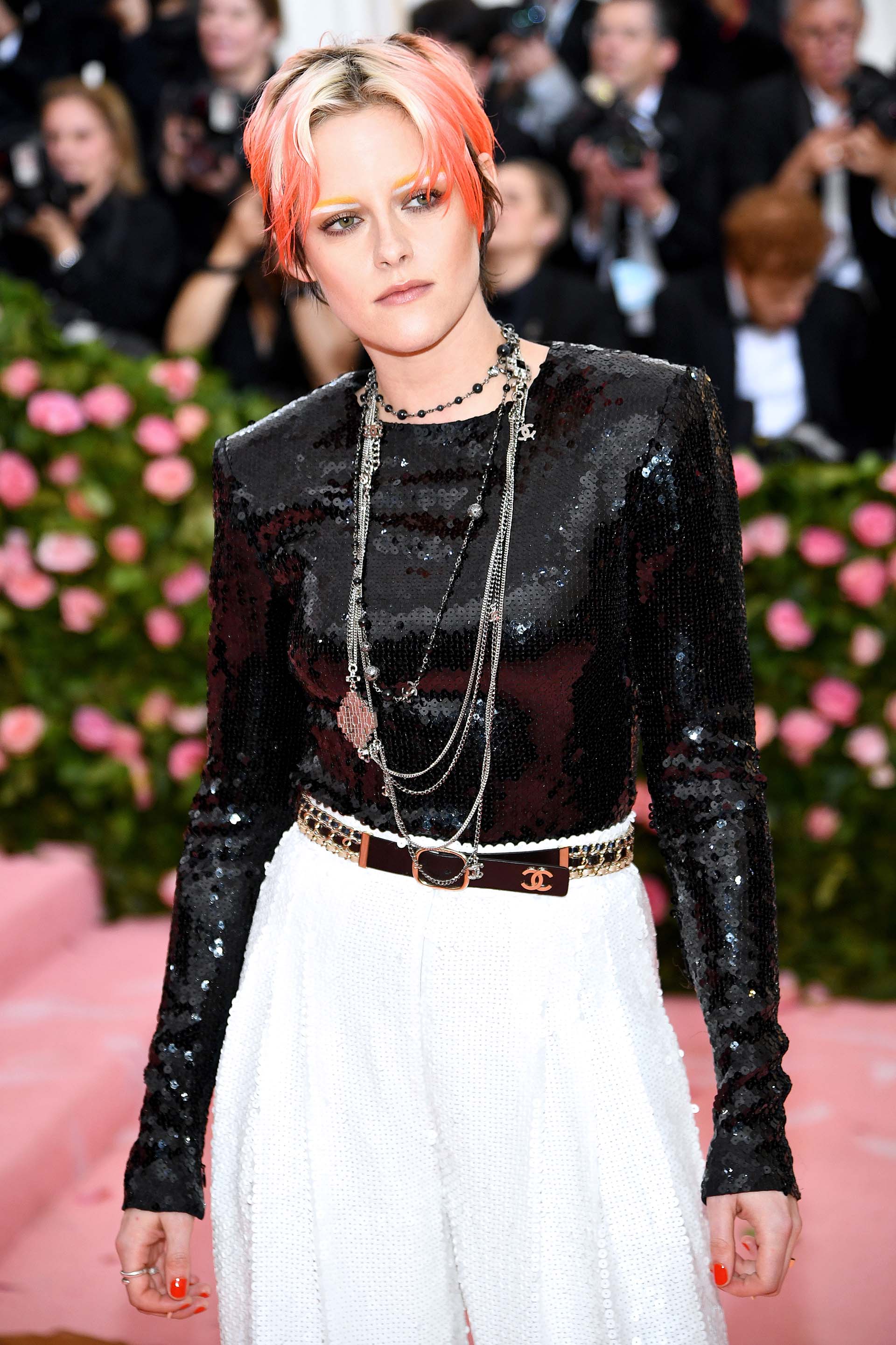 Kristen Stewart lució un top negro y un pantalon de traje blanco de lentejuelas que acompañó con joyas y un cinturón Chanel