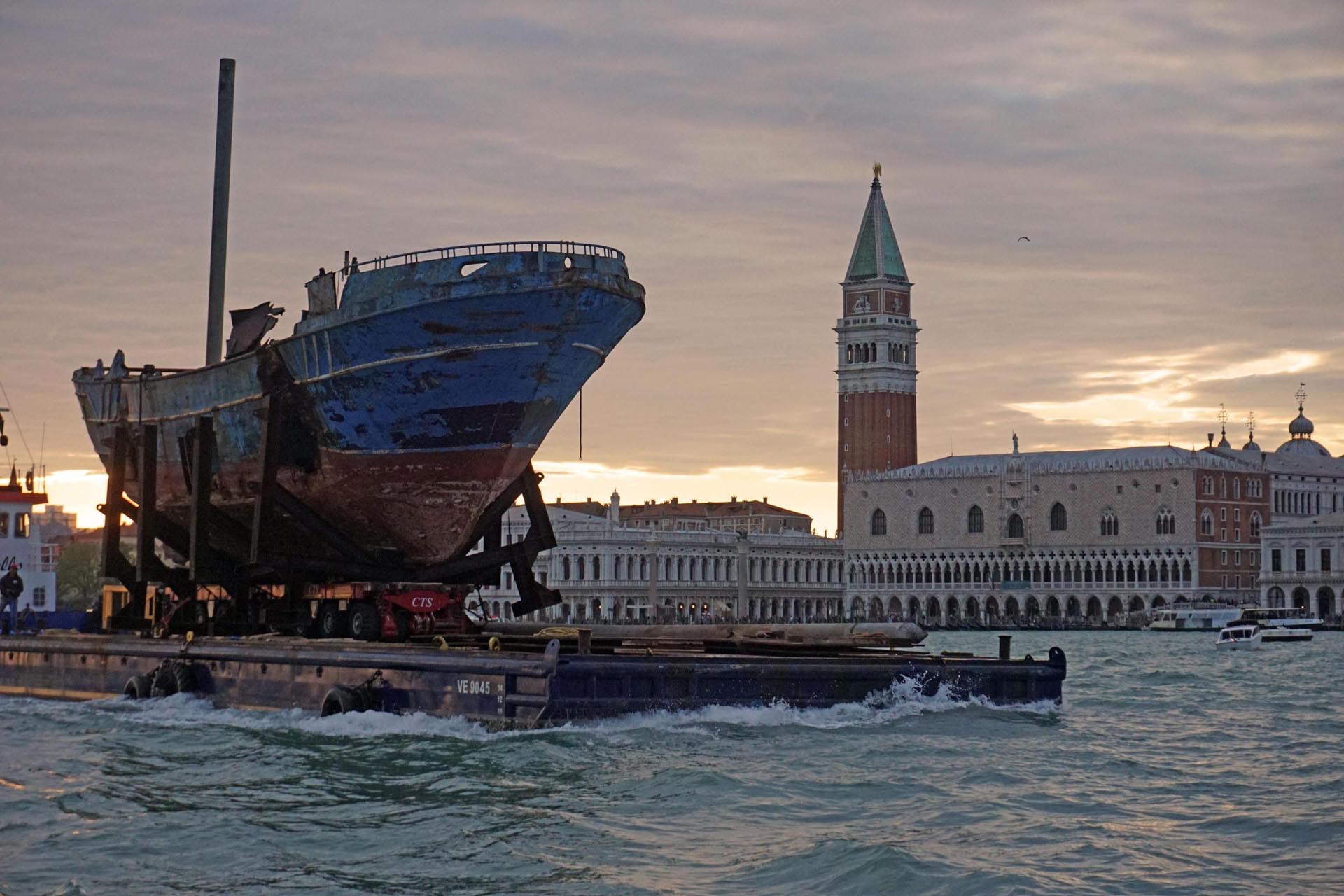 La llegada de la obra del islandés Christoph Bucher, ‘Barca Nostra’, el barco de pesca con 700 inmigrantes a bordo, que se hundió en el Mar Mediterráneo en 2015. (EFE)