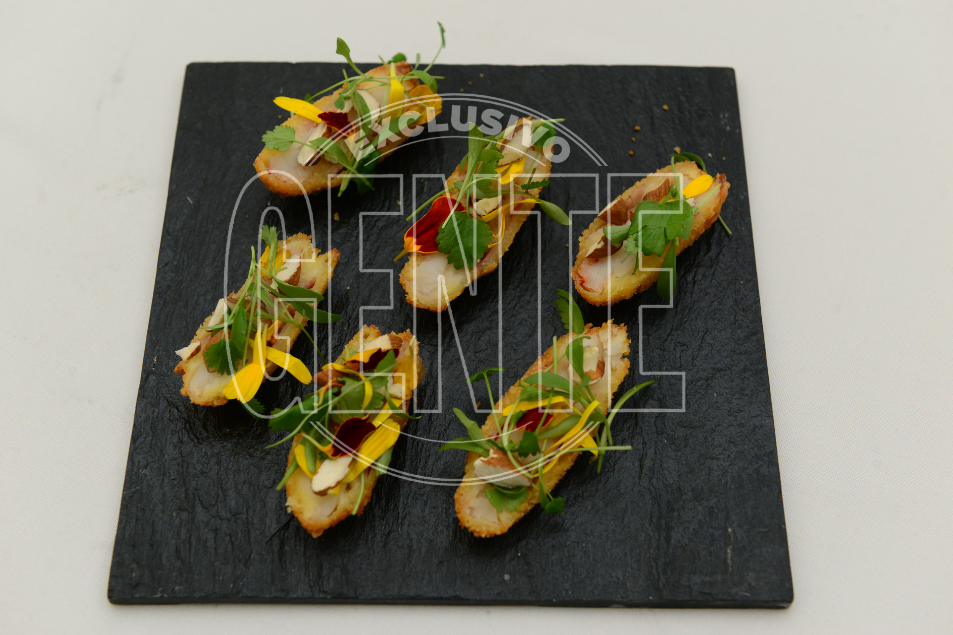 Langostinos con queso, panceta, almendras y cilantro.