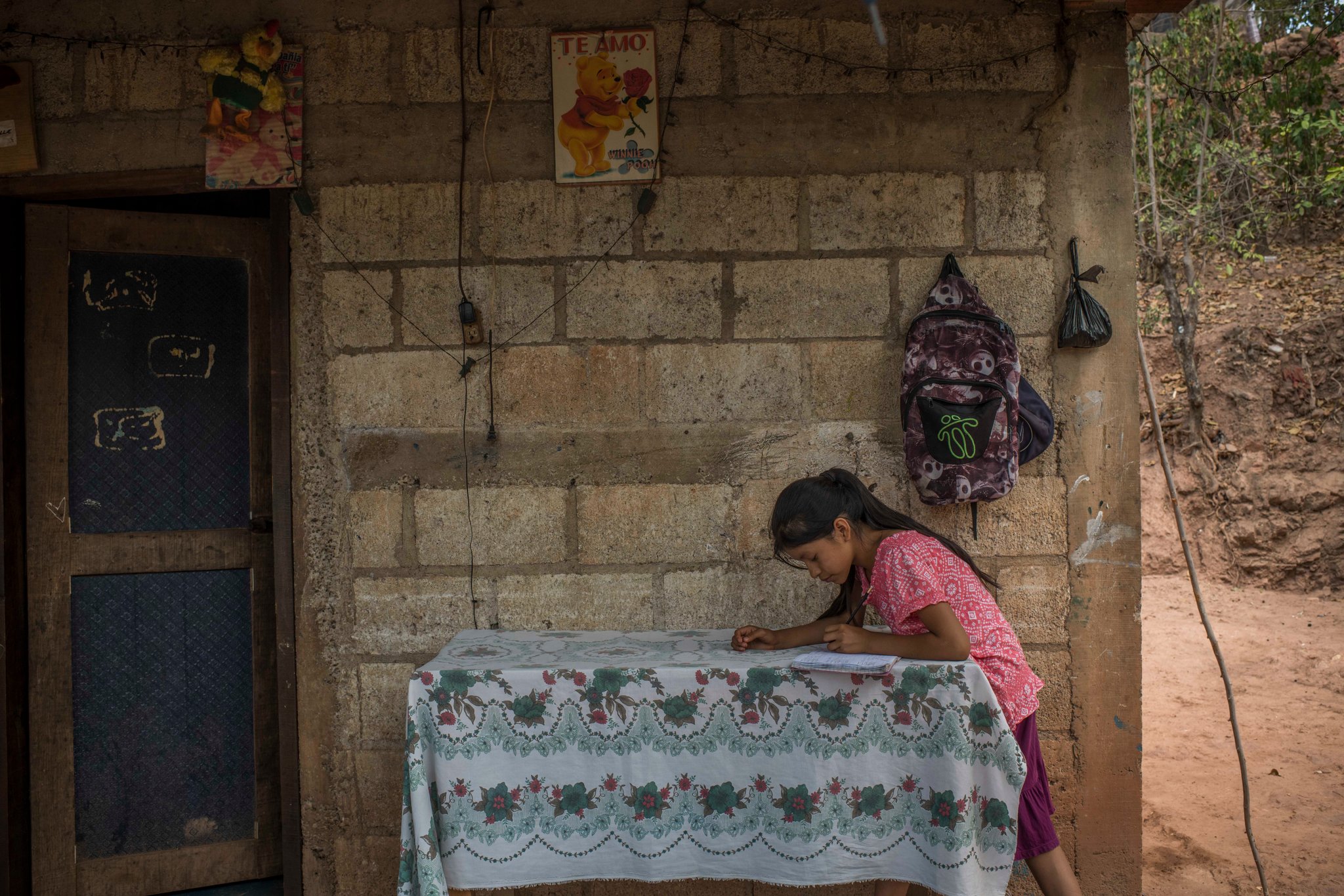 Gabriela Pablo hace la tarea, en el patio de su casa. (Daniele Volpe para The New York Times)