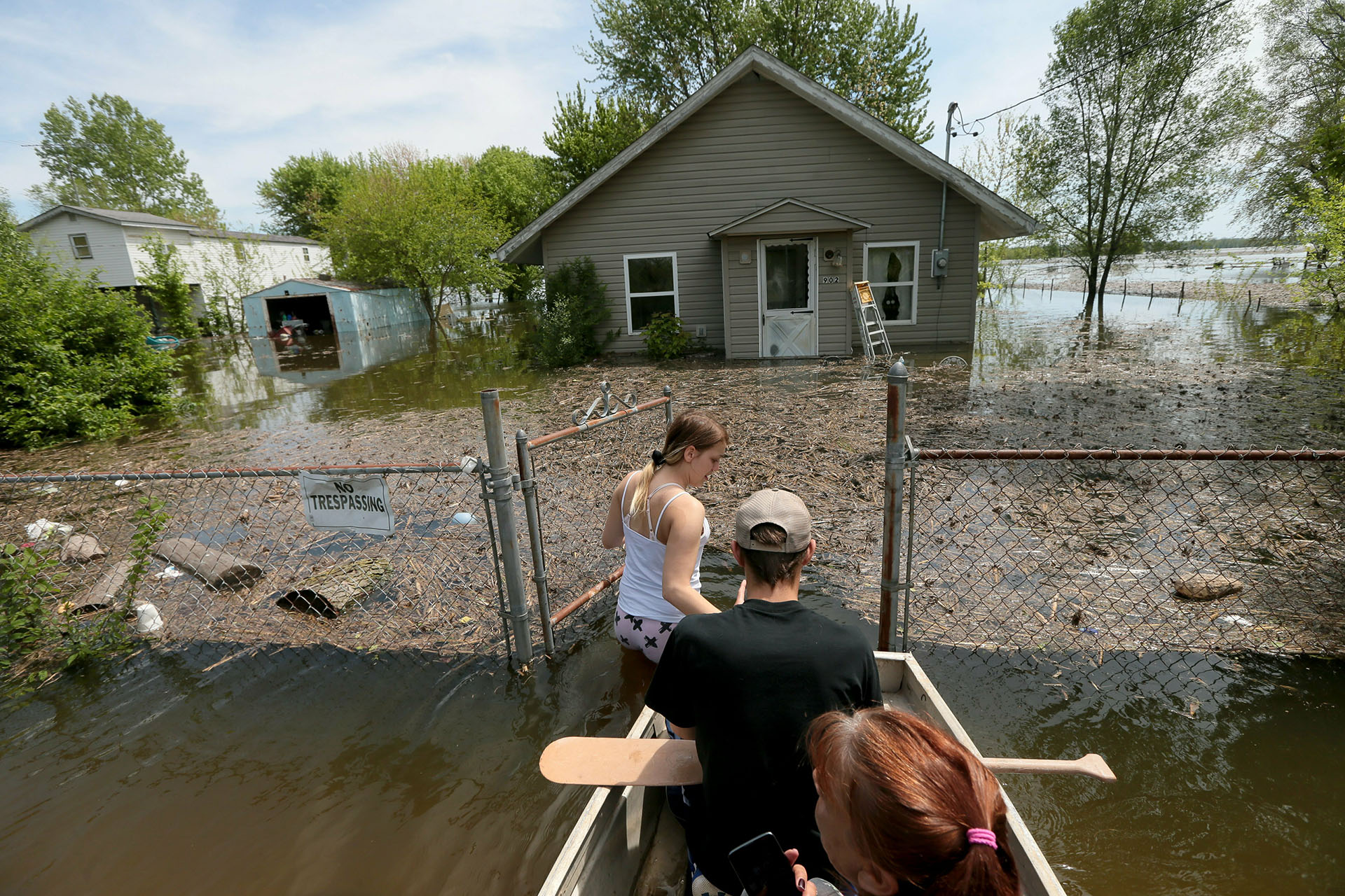Una familia intenta ingresar a su casa en medio de las inundaciones en East Foley, Misuri, el 5 de mayo de 2019. (AP)