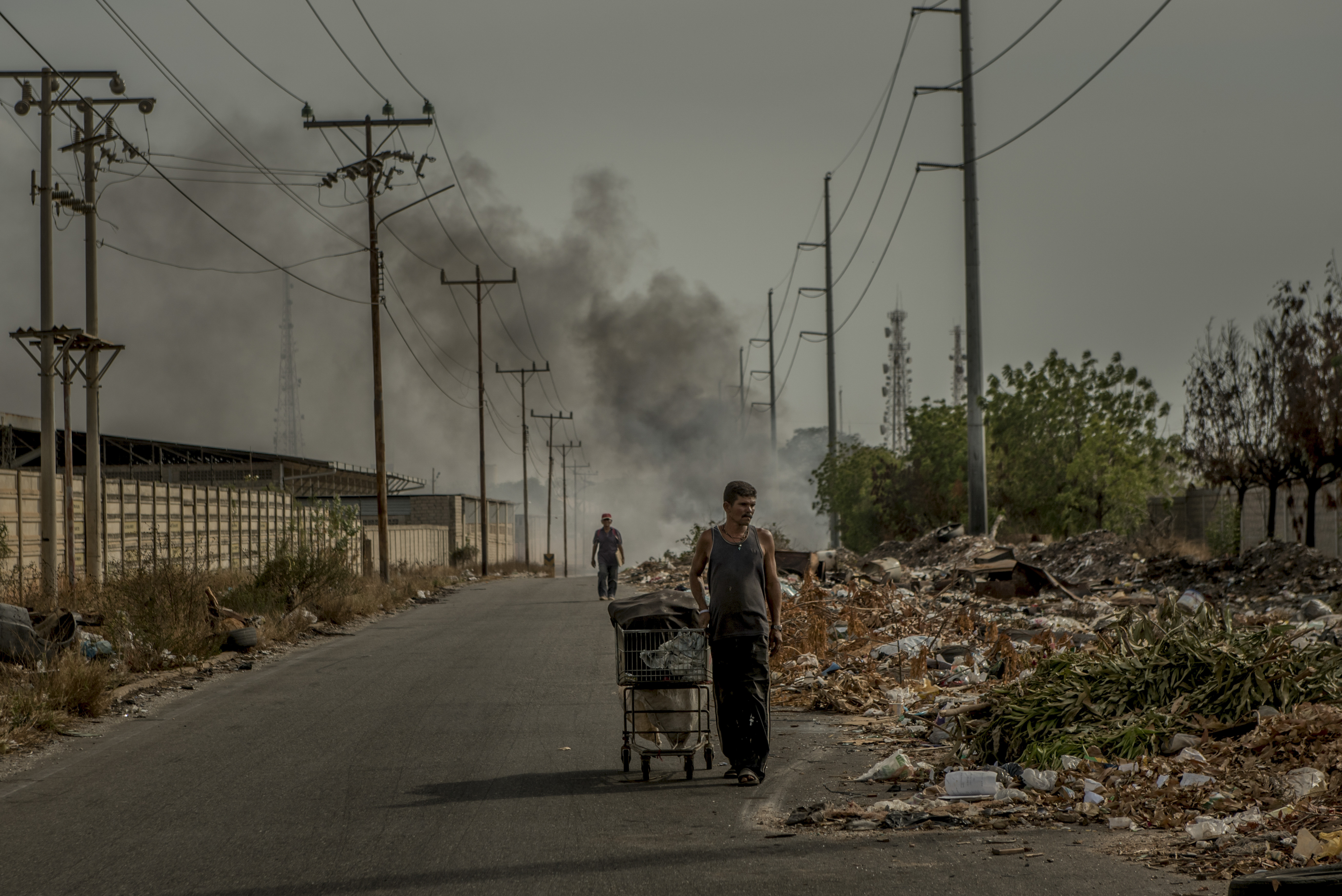 En Maracaibo, dos hombres revisaban los desperdicios en busca de objetos que todavía sirvieran o que pudieran ser reciclados. (Meridith Kohut/The New York Times)