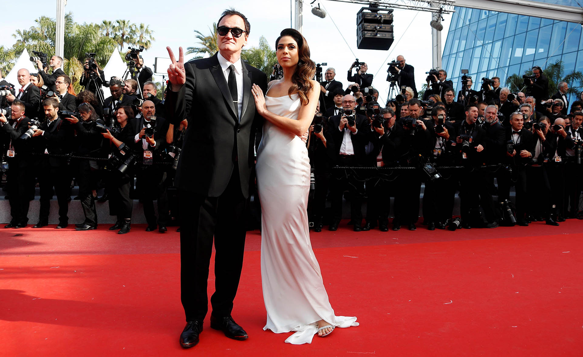Quentin Tarantino y su mujer Daniella Pick. Él apostó a un black tie con corbata slim y ella un vestido blanco con sandalias. Con un beauty look de costado, impactó en la red carpet de Cannes