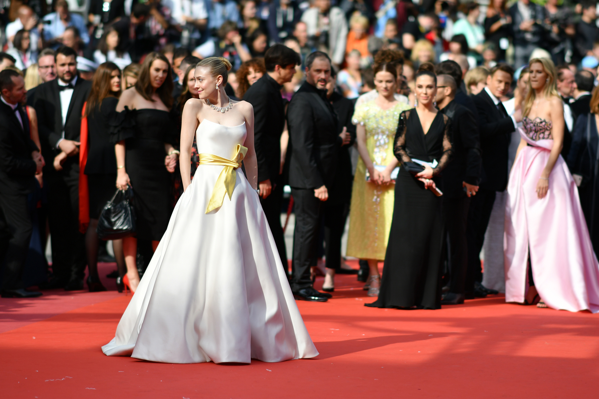Dakota Fanning lució un diseño strapless con lazo amarillo. Completó su look con gargantilla de cristales y pequeños aros colgante