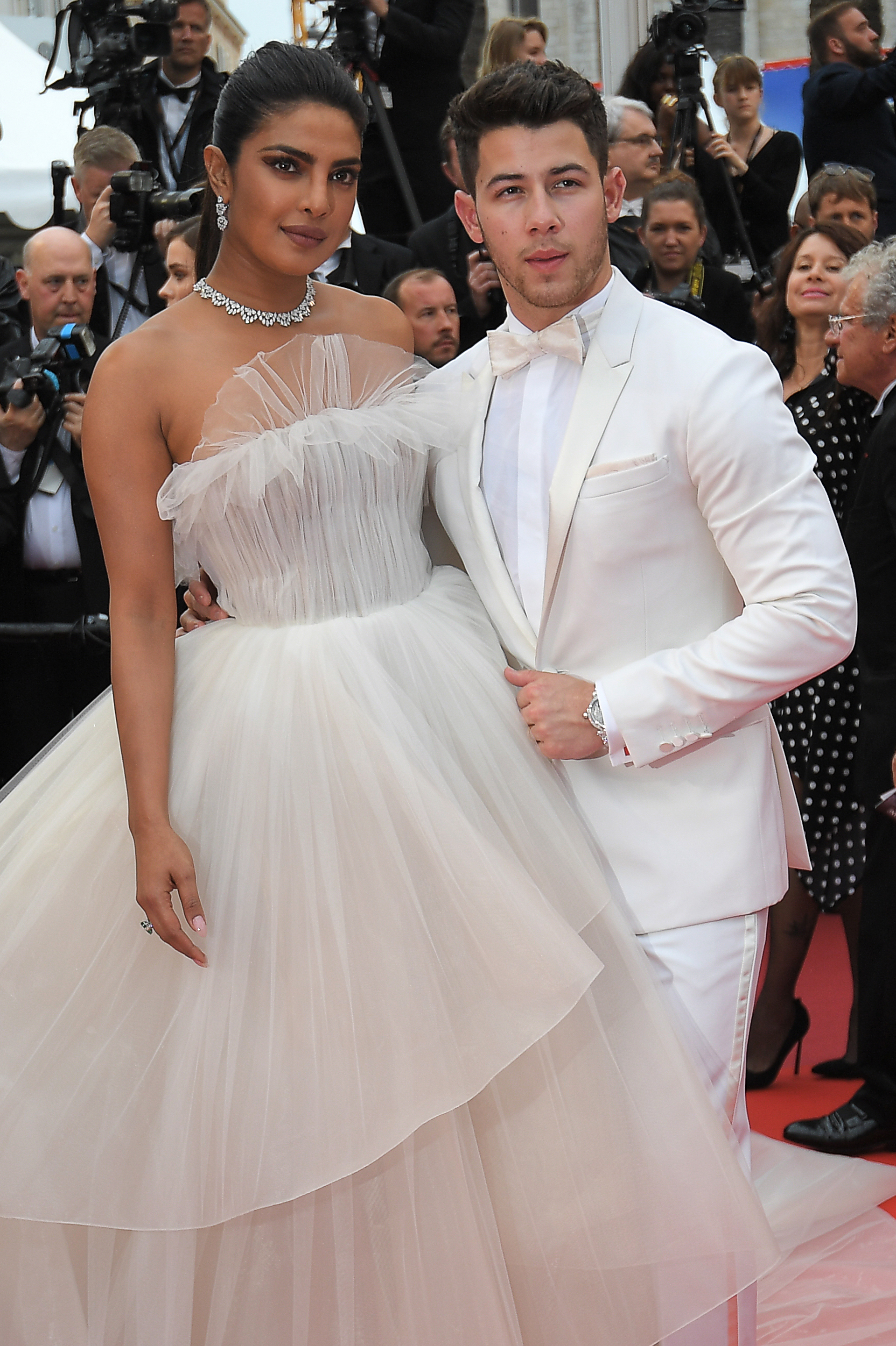 Priyanka Chopra y Nick Jonas en total white. La pareja del momento apostaron al color que transmite paz. Chopra eligió un vestido strapless de tul Georges Hobeika con joyas de Chopard mientras que Nick apostó a un smoking de Berluti con moño
