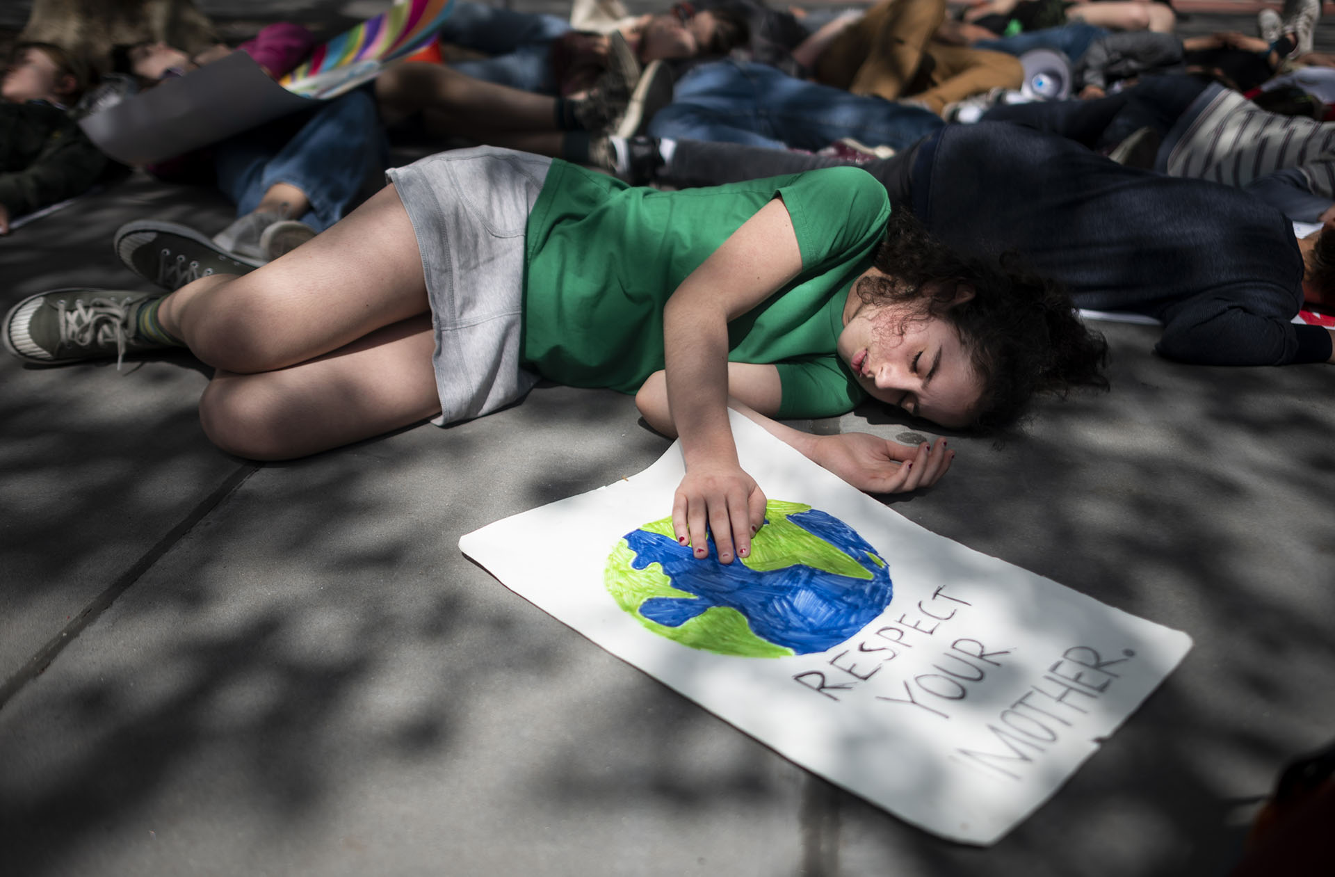 Niños en edad escolar se hacen los muertos durante la Huelga Climática Juvenil el 24 de mayo de 2019 en las afueras de la sede de las Naciones Unidas en la ciudad de Nueva York. (AFP)