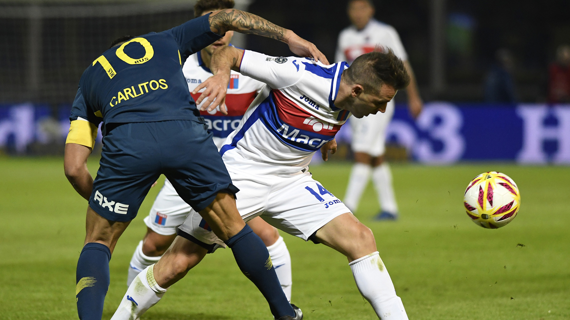Carlos Tevez, de flojo partido, no puede con Walter Montillo (Foto Baires)