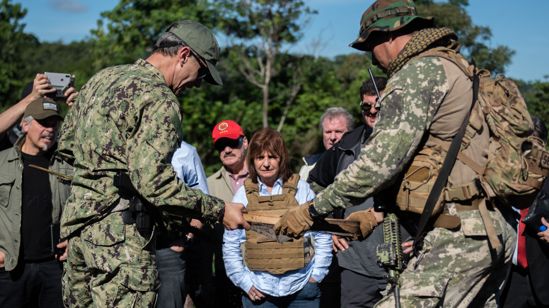 Policías tácticos paraguayos le muestran a Bullrich y a Burzaco el proceso de colado de las plantas ya secas para separar las semillas y las ramas.