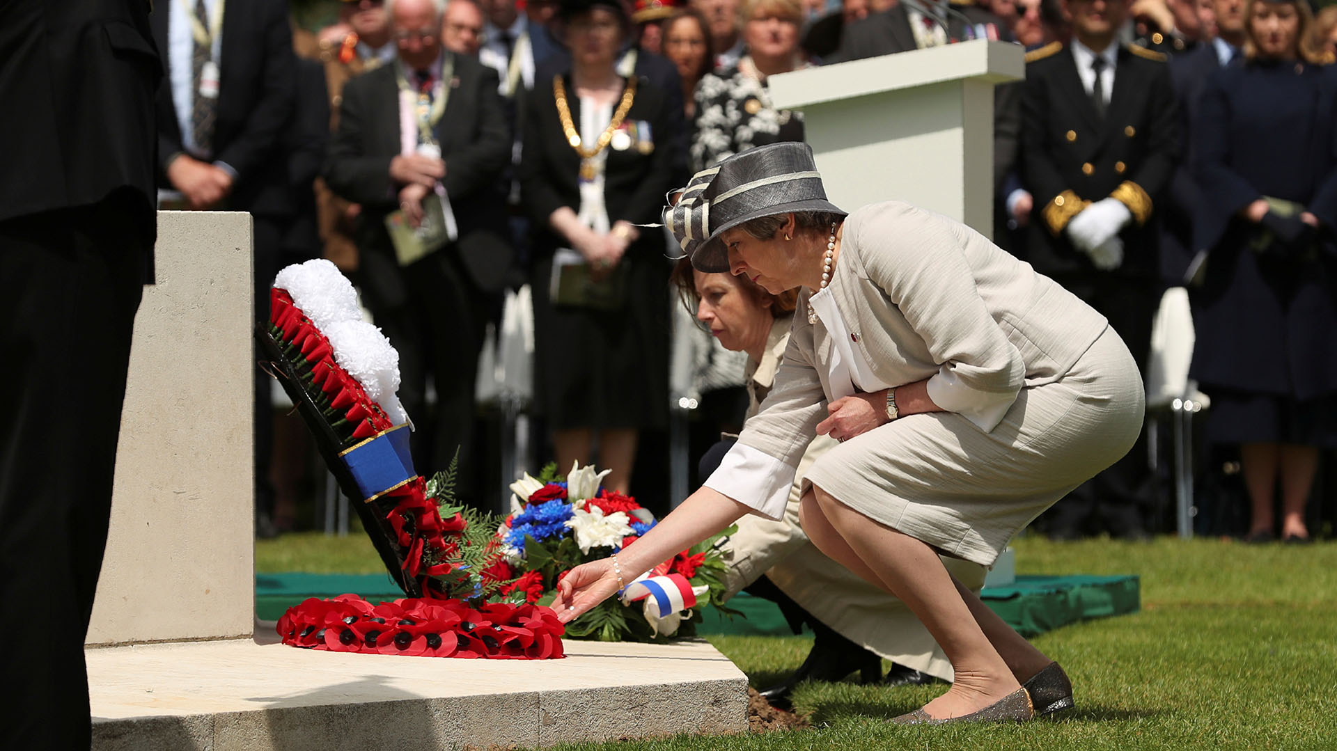 La primera ministra Theresa May junto a la ministra de defensa francesa, Florence Parly, dejan una corona de flores en el cementerio británico (Reuters)