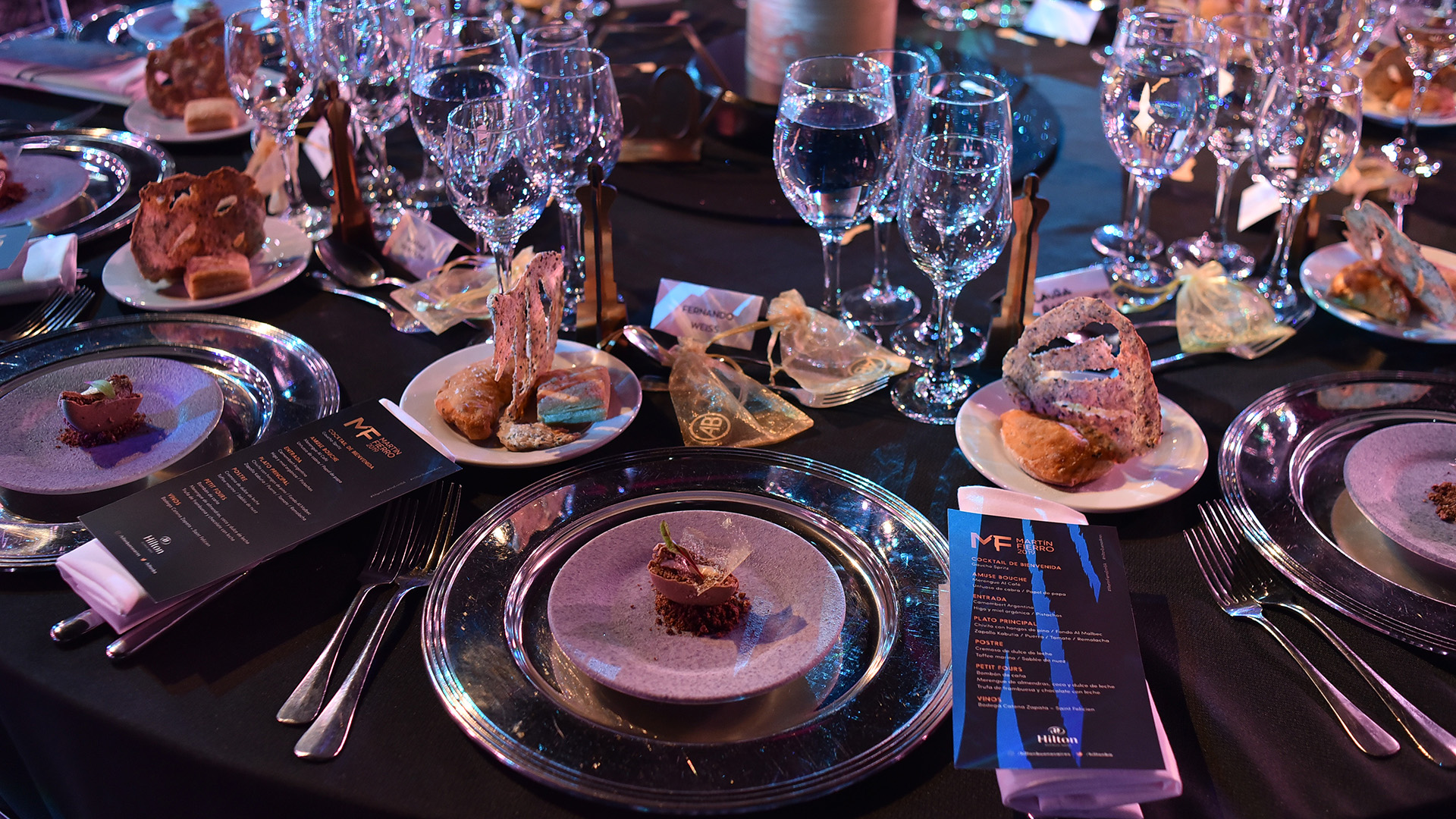 Las lujosas mesas en el salón Pacífico del Hilton. El menú: de entrada, Camembert Argentino con higos, miel orgánica y pistachios; plato principal, chivito con hongos de pino con zapallo kabutia, puerros, tomate y remolacha; de postre, cremoso de dulce de leche, toffee marino y sablée de nuez. Luego, petit fours y café