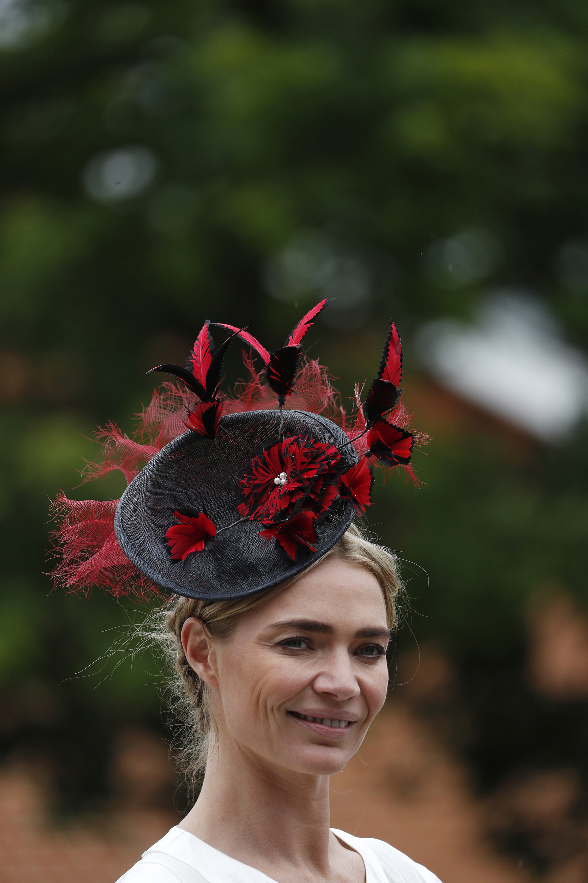 Jodie Kidd con fascinator combinado en rojo y negro. Con plumas y tejido en red