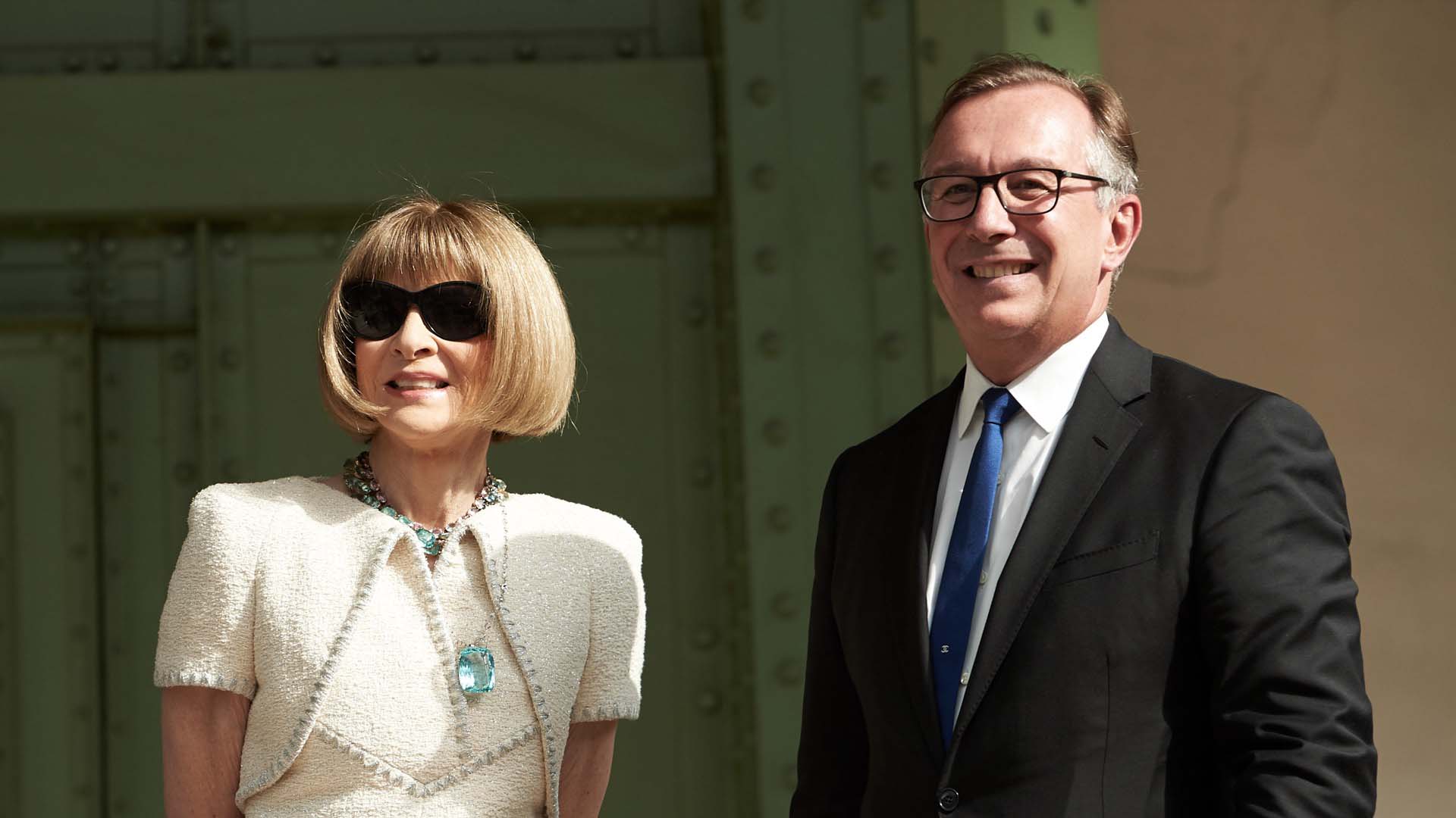 Anna Wintour con un vestido de tweed de Chanel con chaqueta torera a conjunto que llevó con unas llamativas joyas y sus inseparables gafas de sol. Junto a Bruno Pavlovsky.