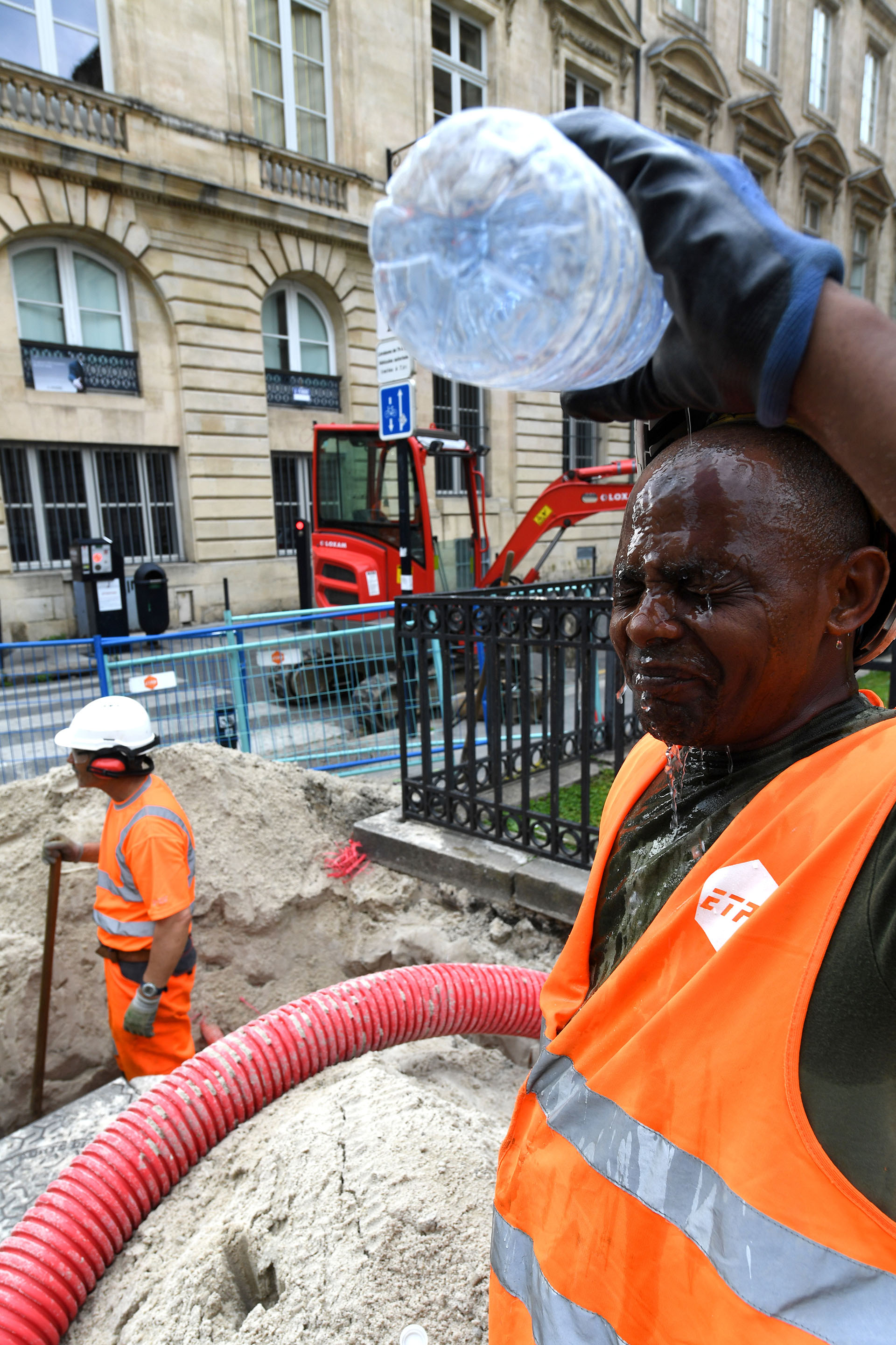 Trabajadores usan agua para combatir el calor en París (AFP)