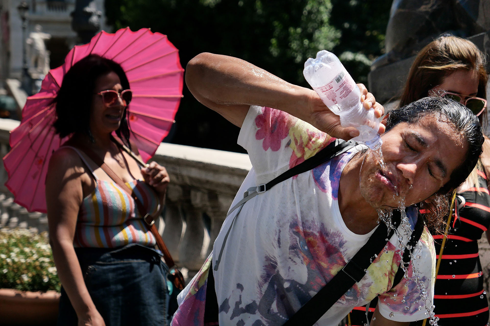 Turistas utilizan paraguas y agua fresca para combatir el calor en Roma (Alberto Pizzoli/ AFP)