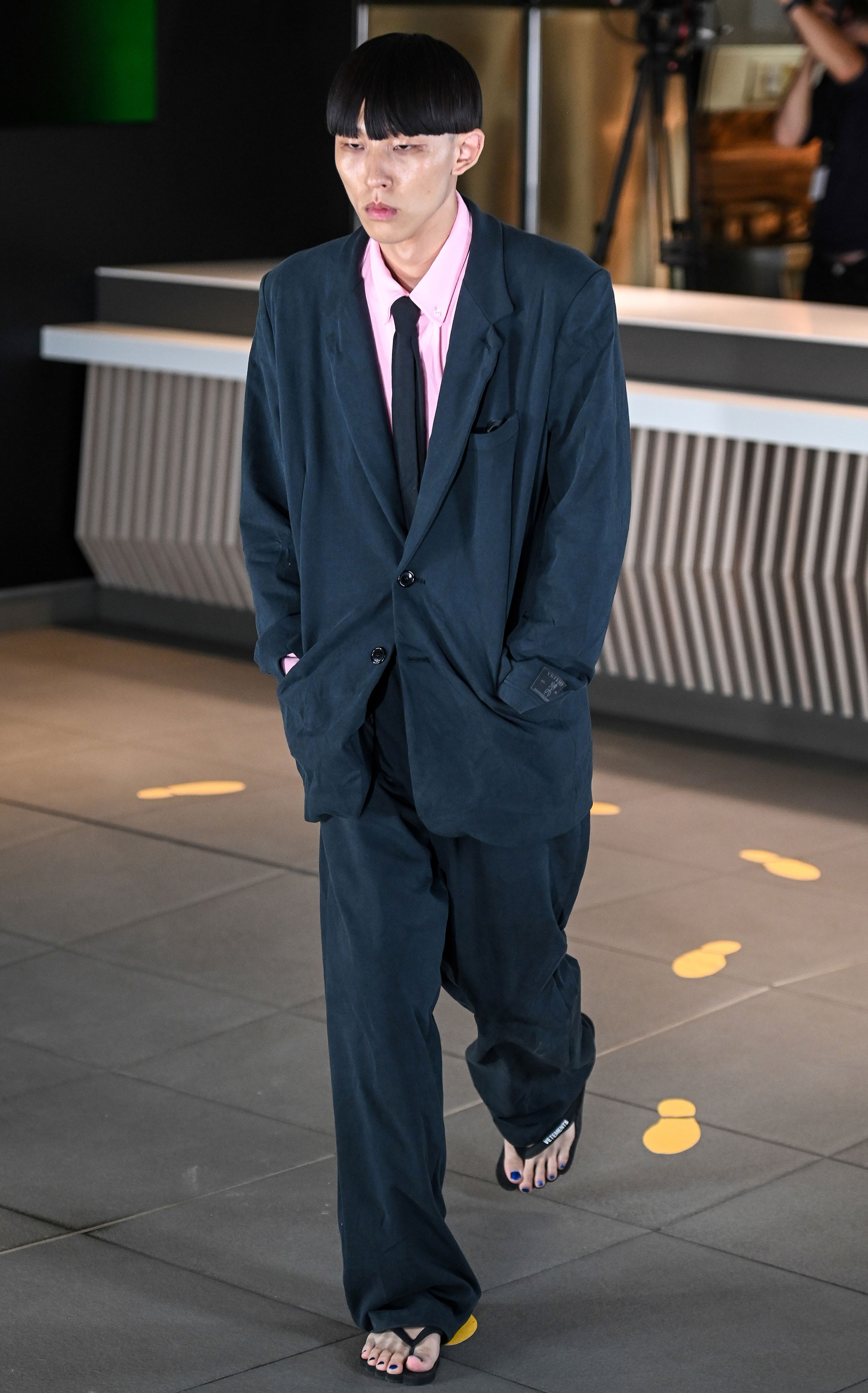 Como todas las colecciones de hombres Vetements también presentó sastrería. Oversized en color azul petróleo combinado con ojotas con camisa rosa y slim tie fueron parte de la propuesta de la firma