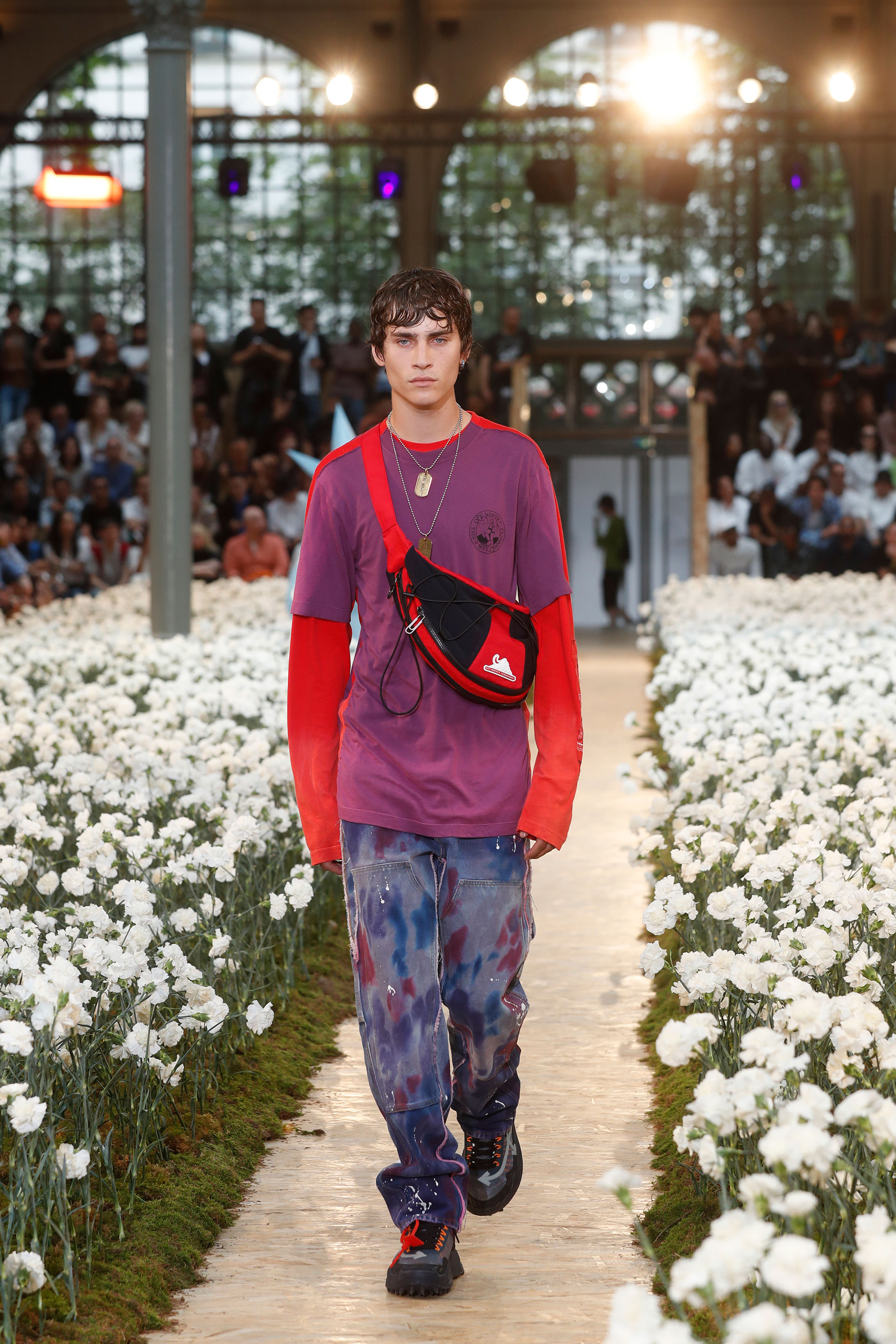 Relajado y entrecasa. De mangas largas, una remera de algodón en púrpura y rojo combinada con pantalones cargo pintados. Los accesorios fashionistas, una riñonera, las ugly shoes de hombres y collares con chapas